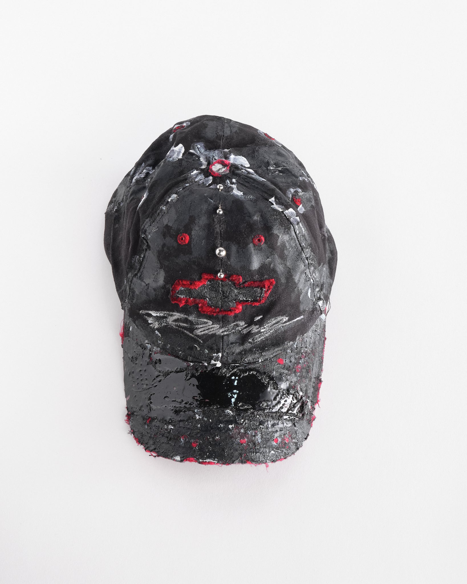 Top front of Black and red Chevy Racing hat customized by ASTROBOI* with distressing, painted details, glossy resin visor, and stainless steel piercings.