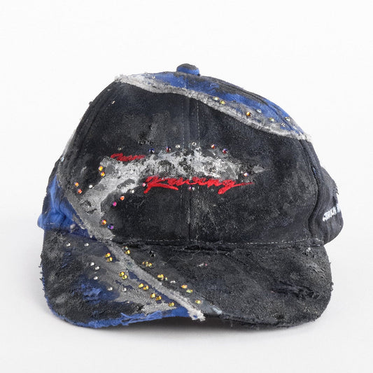 Front of ASTROBOI* black and blue distressed racing hat with metallic paint, rhinestones, and airbrushed details, handcrafted in NYC.