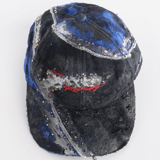 Overview of ASTROBOI* black and blue distressed racing hat with metallic paint, rhinestones, and airbrushed details, handcrafted in NYC.