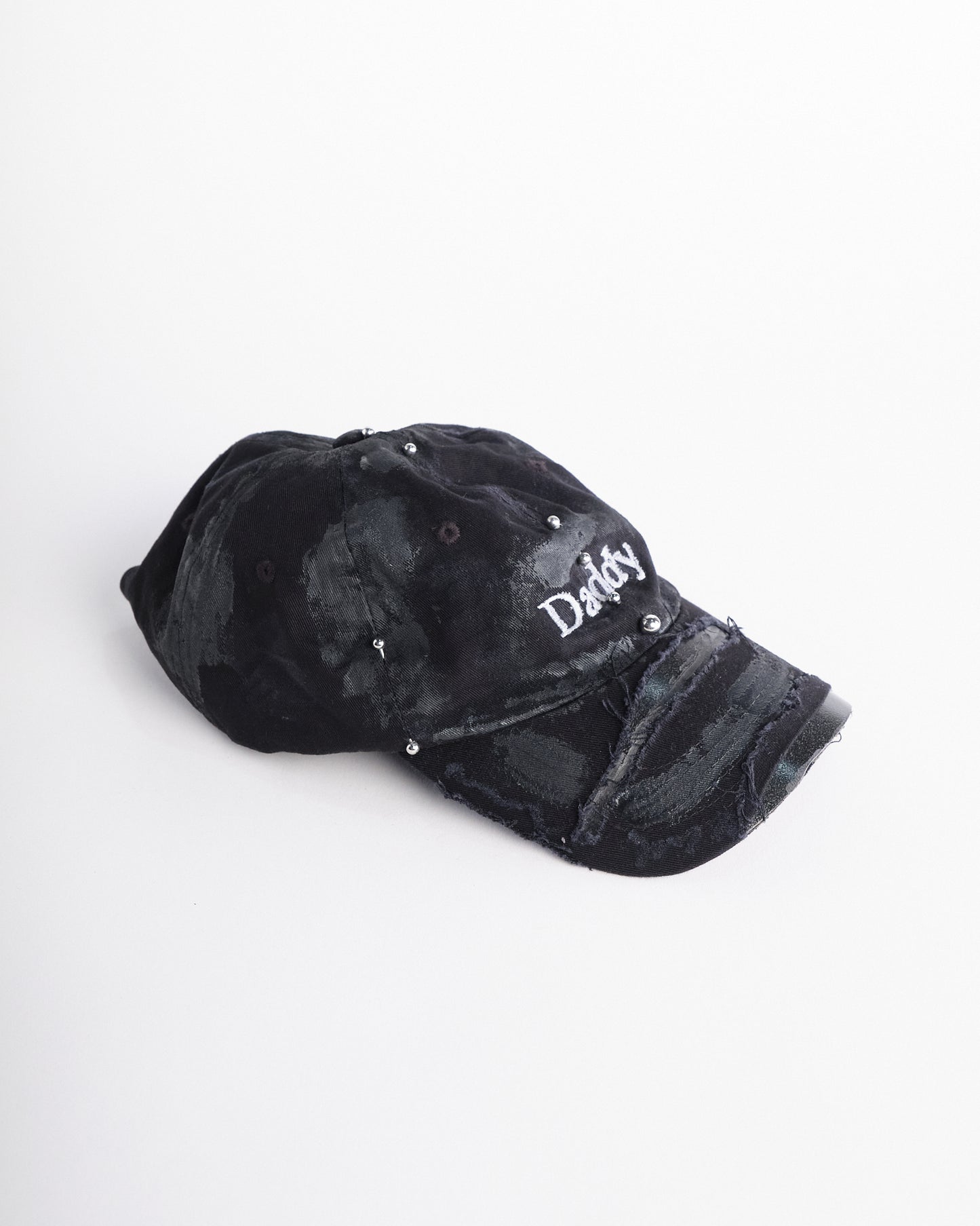 Right side of Black distressed ASTROBOI* ‘Daddy’ hat with custom paint detailing and stainless steel piercings, handcrafted in NYC.