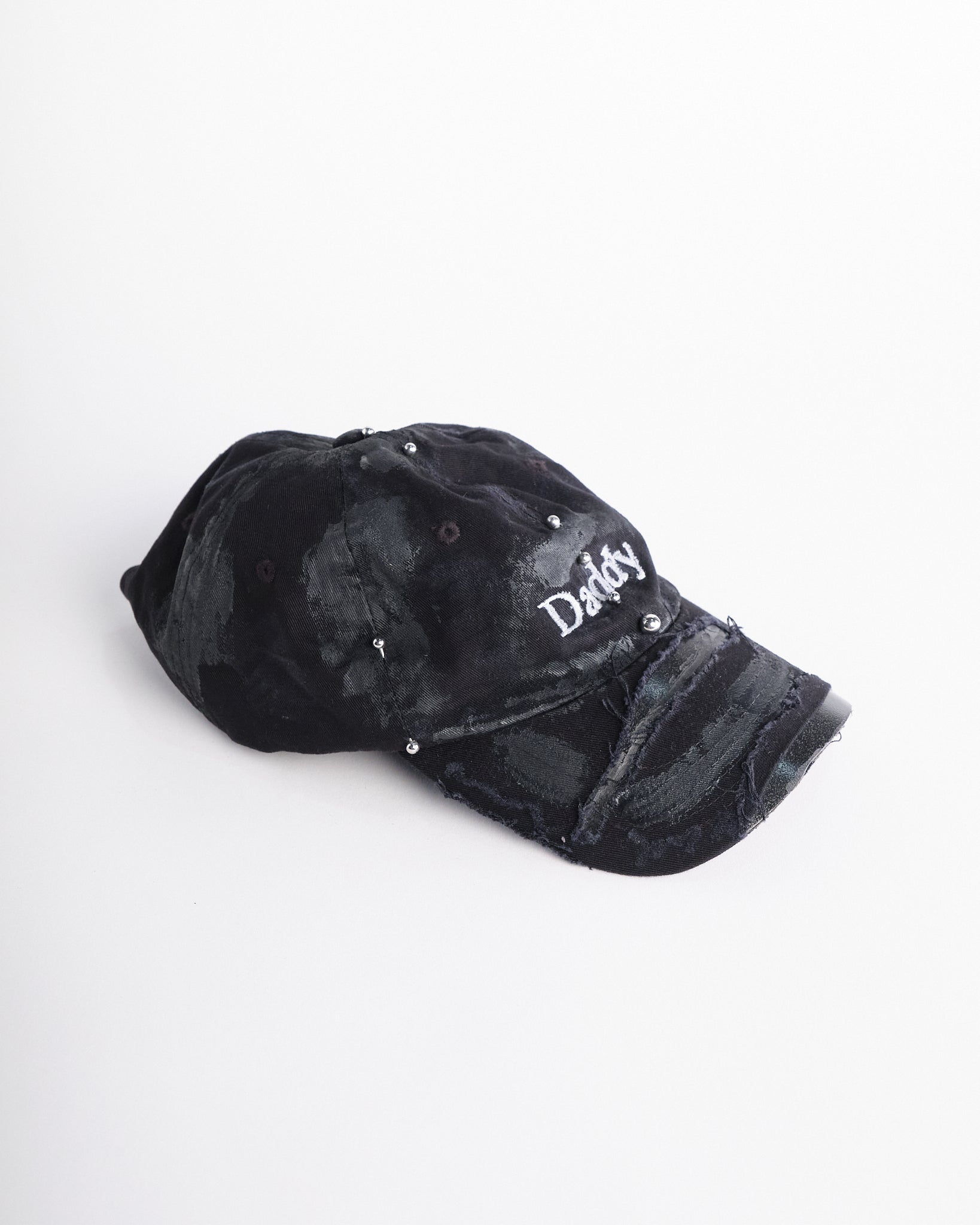 Right side of Black distressed ASTROBOI* ‘Daddy’ hat with custom paint detailing and stainless steel piercings, handcrafted in NYC.
