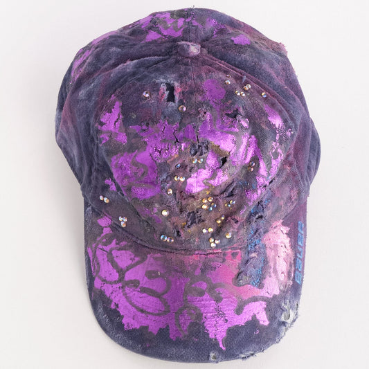 Overview of ASTROBOI* x Bauer purple distressed hat with metallic paint detailing, clustered rhinestones, and closed-back fit, handmade and customized in NYC.
