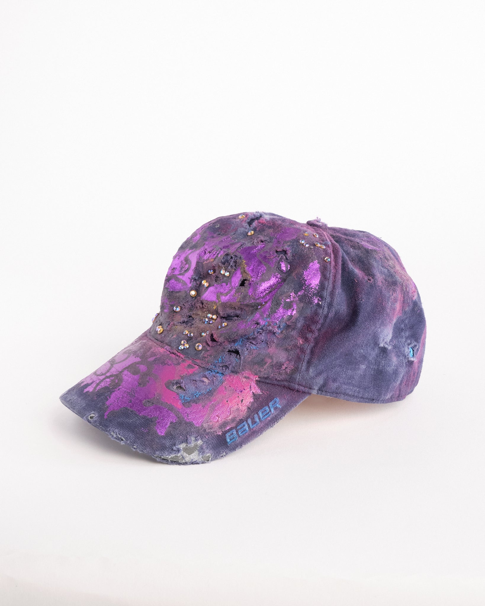 Left of ASTROBOI* x Bauer purple distressed hat with metallic paint detailing, clustered rhinestones, and closed-back fit, handmade and customized in NYC.
