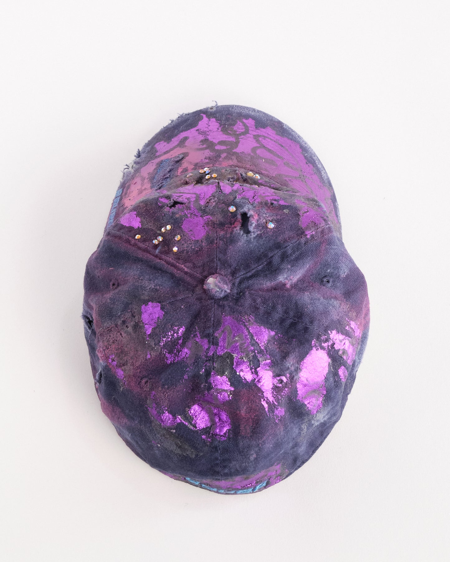 Top of ASTROBOI* x Bauer purple distressed hat with metallic paint detailing, clustered rhinestones, and closed-back fit, handmade and customized in NYC.