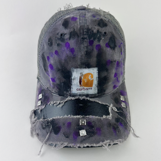 ASTROBOI* x Carhartt 'Amethyst' gray and purple distressed studded hat with Carhartt logo patch at center front, black and purple paint treatment, and silver studded deconstructed visor, front view.
