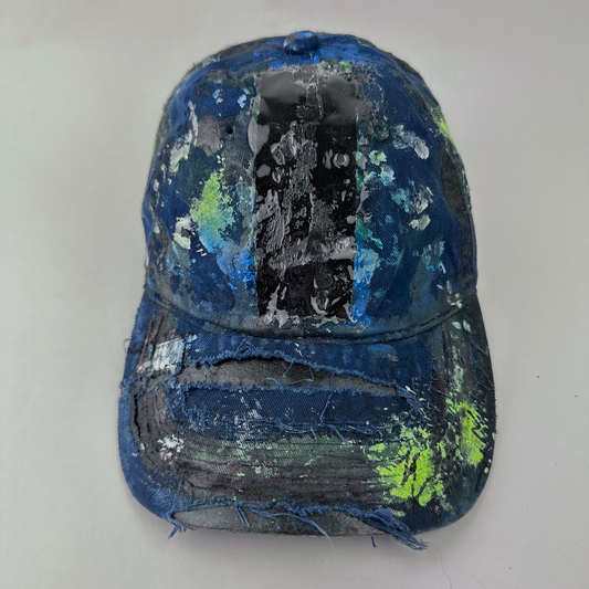 ASTROBOI* 'Coral' blue distressed painted cap with black, white, and blue speckled paint splatter treatment and deconstructed visor with melted duct tape and 3D resin detail, front view.