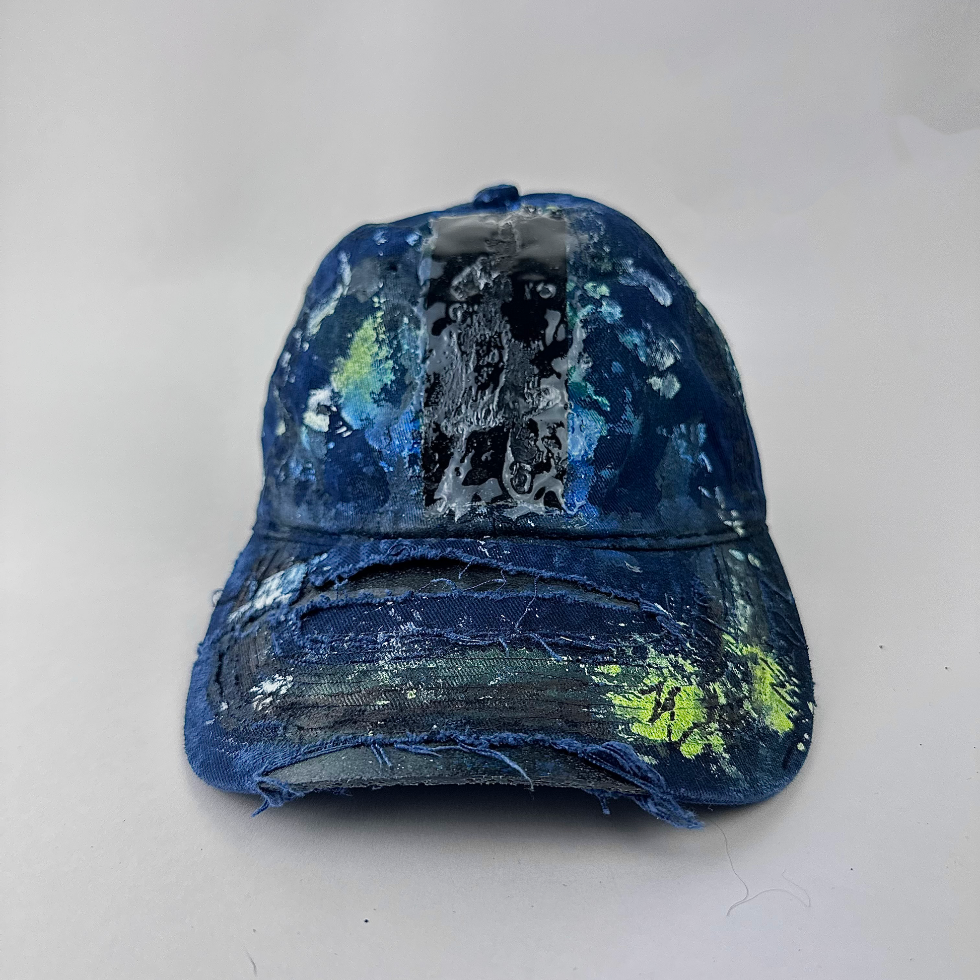 ASTROBOI* 'Coral' blue distressed painted cap with black, white, and blue speckled paint splatter treatment and deconstructed visor with melted duct tape and 3D resin detail, front view two.