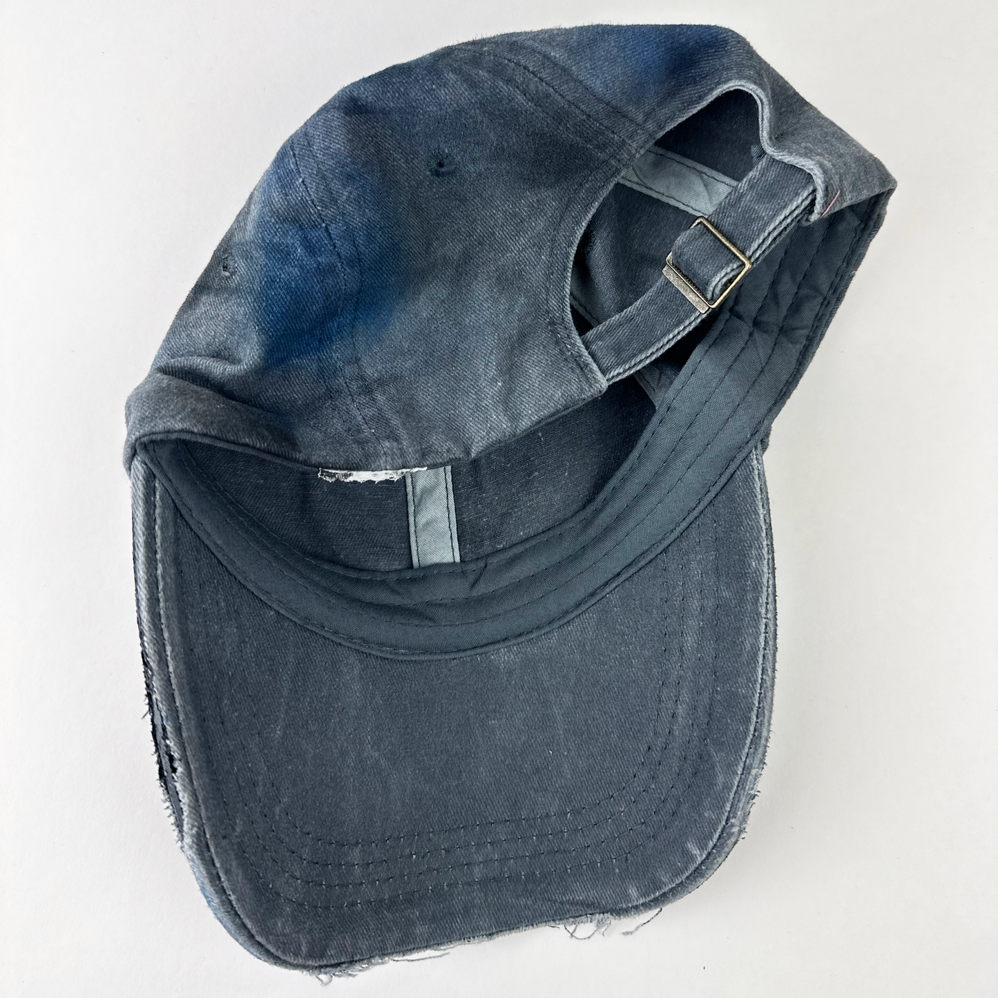 Back view of ASTROBOI* 'Duct' showing distressing, fading, and custom paint treatment on blue denim grunge base.