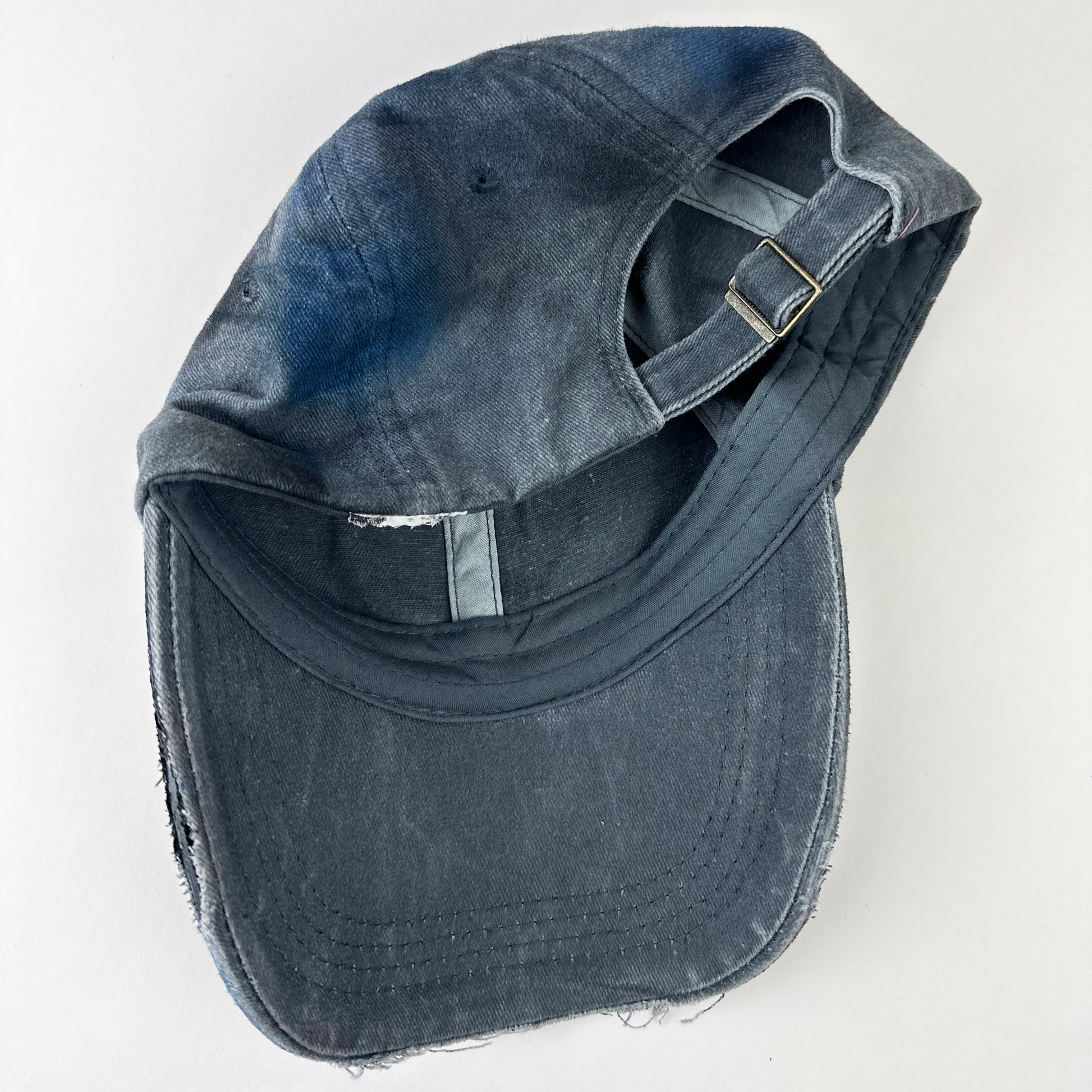 Back view of ASTROBOI* 'Duct' showing distressing, fading, and custom paint treatment on blue denim grunge base.