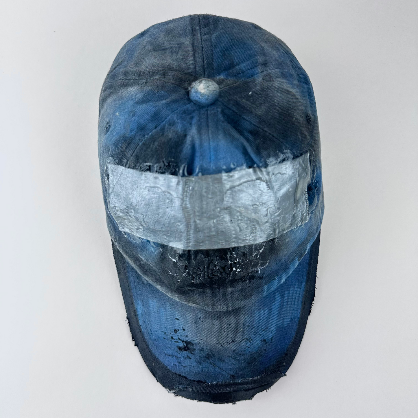 Top view of ASTROBOI* 'Duct' showing barbed wire design detail and melted duct tape sealed under clear resin on distressed blue denim fabric.
