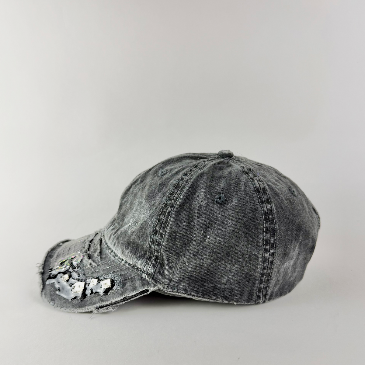 Side view highlighting distressed denim texture and silver stud detailing.