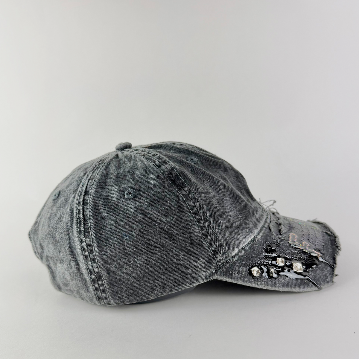 Side detail of ASTROBOI* 'FAG' showing distressed black denim and silver stud embellishments.