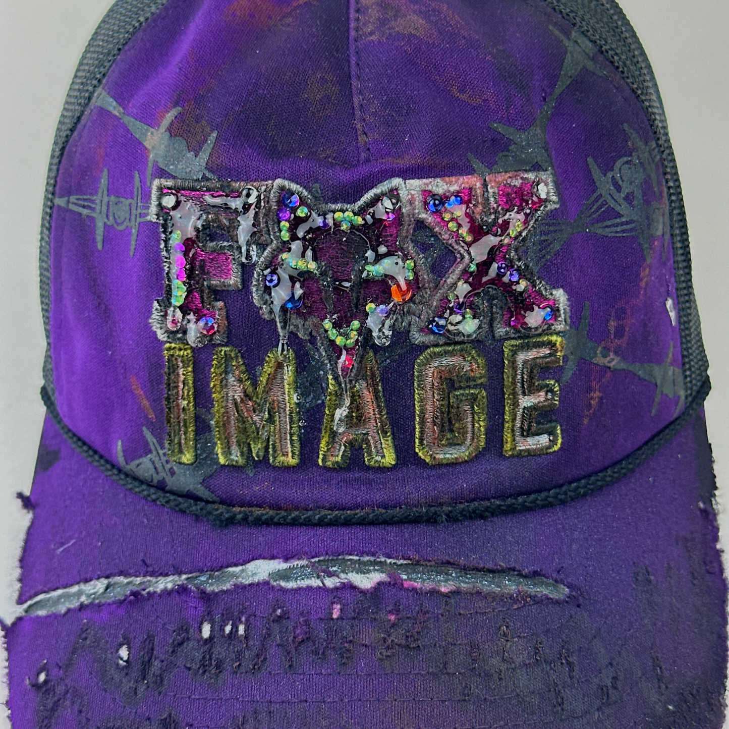 Close-up of ASTROBOI* x Fox Racing 'Barbed Wire' showing multicolored rhinestone embellishment on Fox image branding and custom paint treatment.