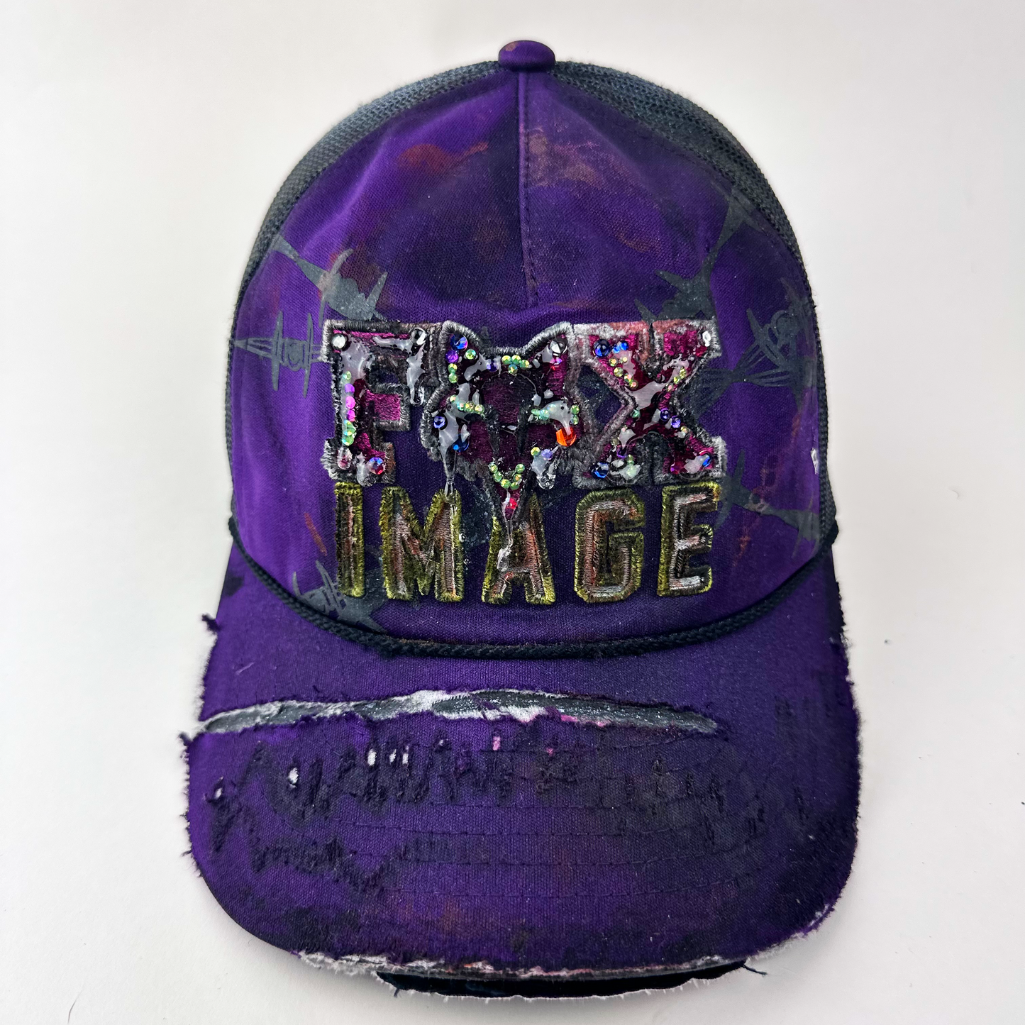 ASTROBOI* x Fox Racing 'Barbed Wire' purple hat with multicolored rhinestone-embellished Fox image branding at front and deconstructed visor, front view.