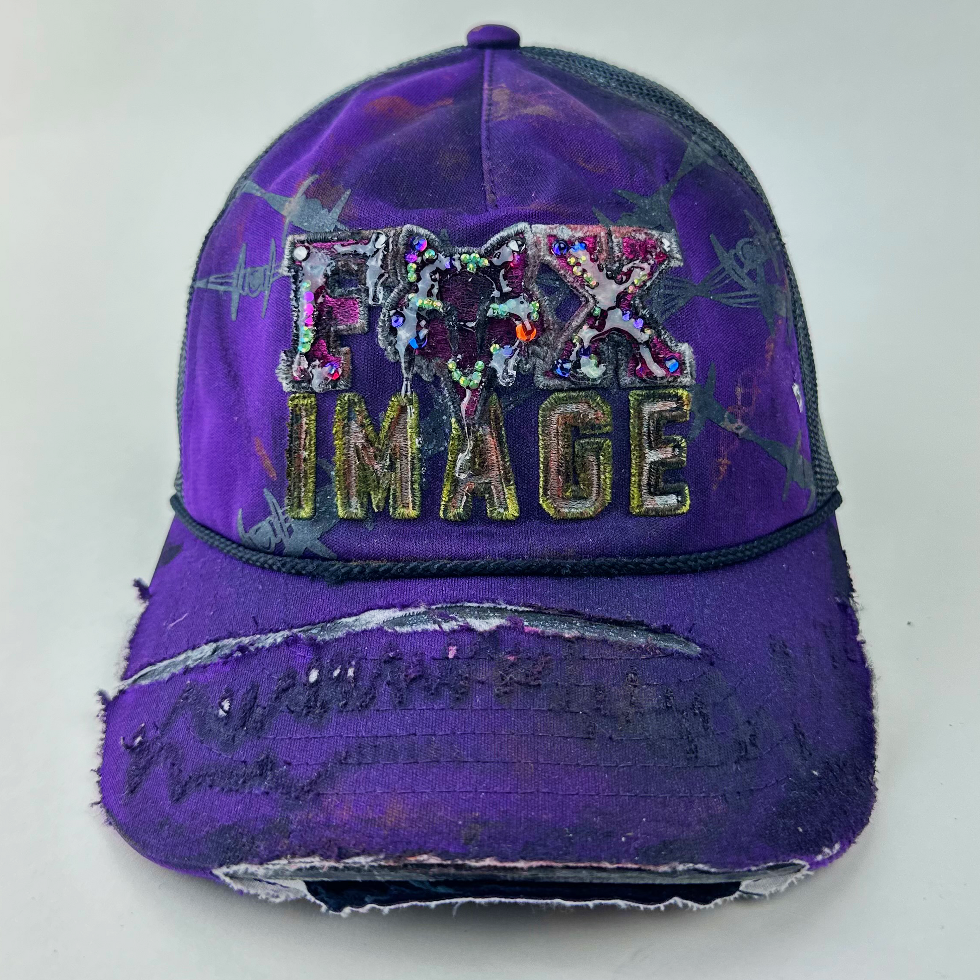 ASTROBOI* x Fox Racing 'Barbed Wire' purple hat with multicolored rhinestone-embellished Fox image branding at front and deconstructed visor, front view.