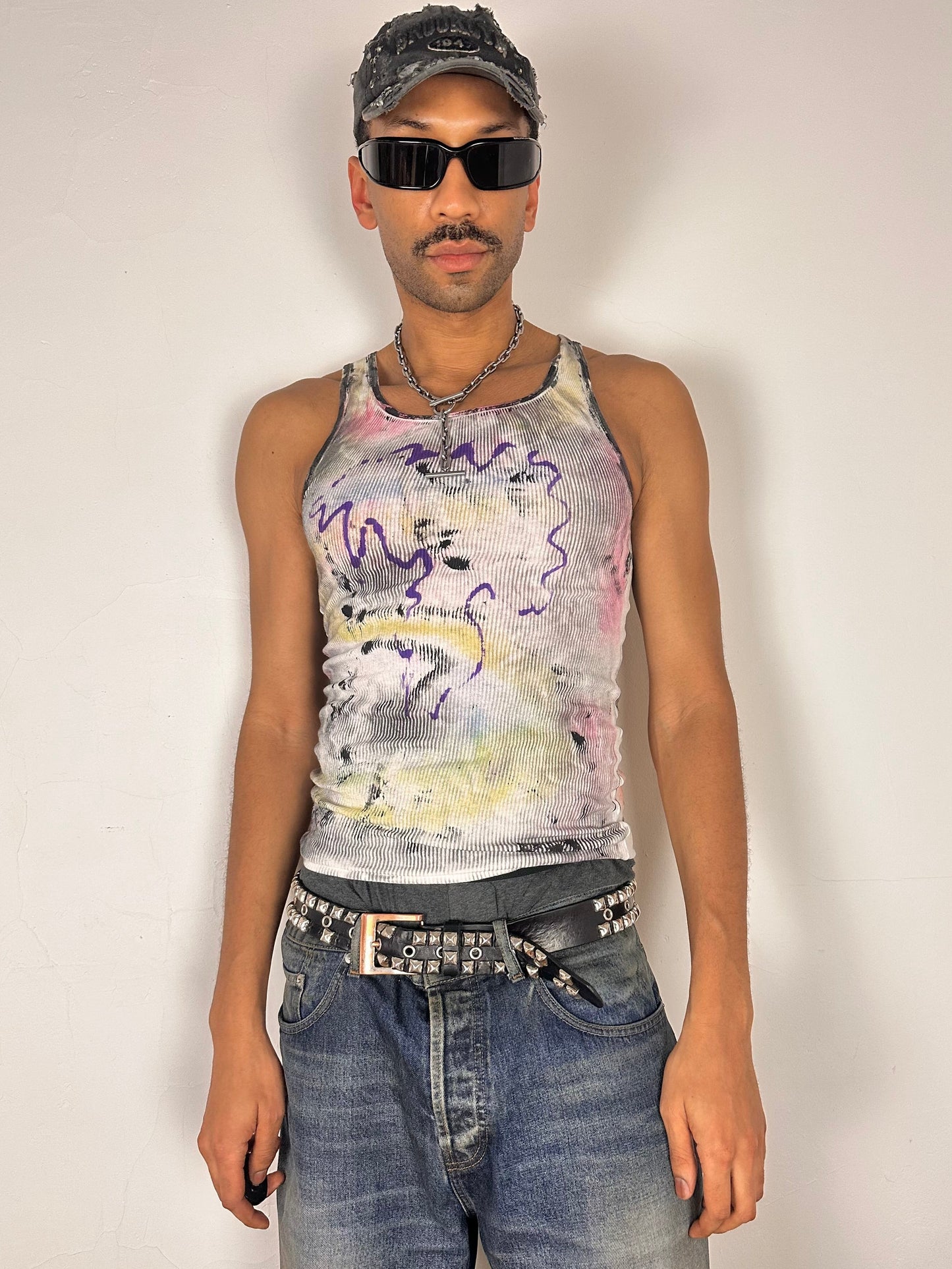 Styled image of ASTROBOI* x Hanes 'Plum' white slim-fit tank top with hand-painted multicolor abstract scribble graphic in pink, yellow, blue, and purple, customized at ASTROBOI* STUDIO in NYC.