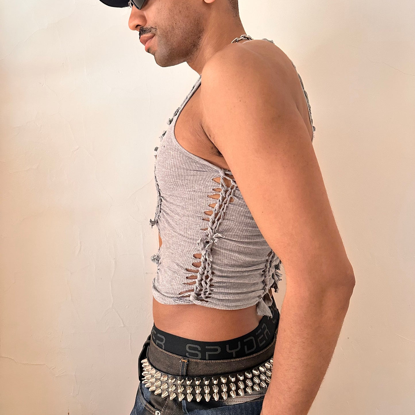 Left side detail of ASTROBOI* 'Ambiguous' showing hand-braided arrangement and slash detailing on cropped gray tank.