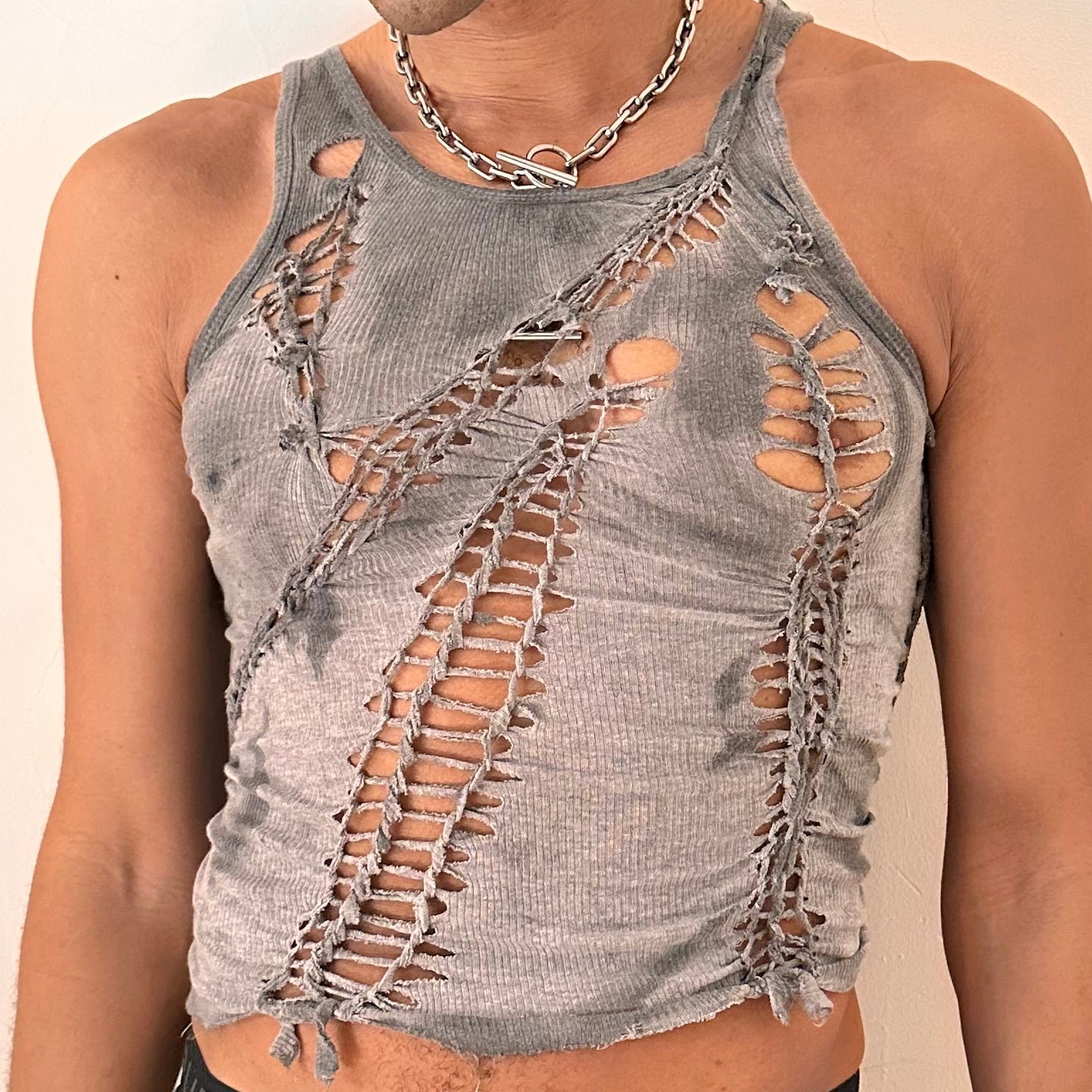 Close-up of ASTROBOI* x Gildan 'Stone' showing hand-braided construction, knot and cut-out detailing, and tonal sun-faded paint treatment on antique gray cotton.