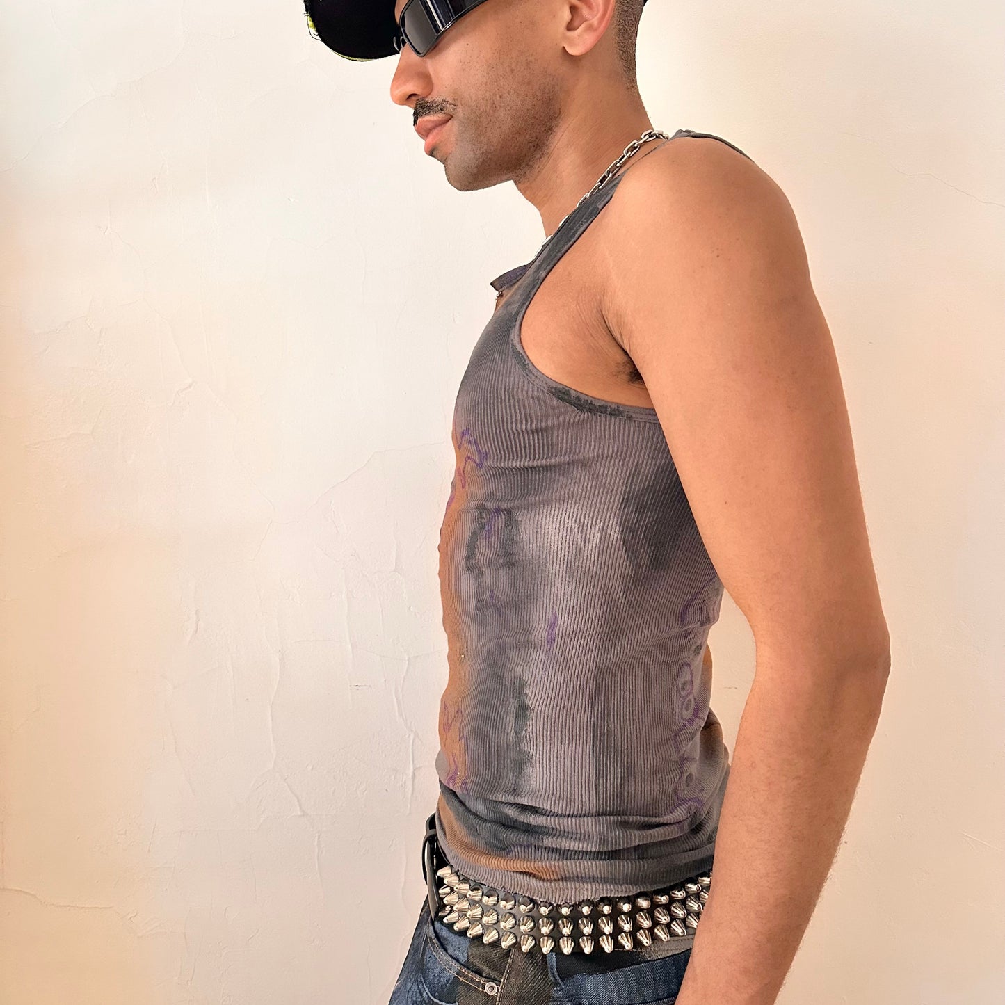 Left side of ASTROBOI* x Gildan 'Graffiti' gray ribbed slim-fit tank top with hand-painted purple, white, black, and orange abstract graffiti design and intentional raw rip at the collar, customized at ASTROBOI* STUDIO in NYC.