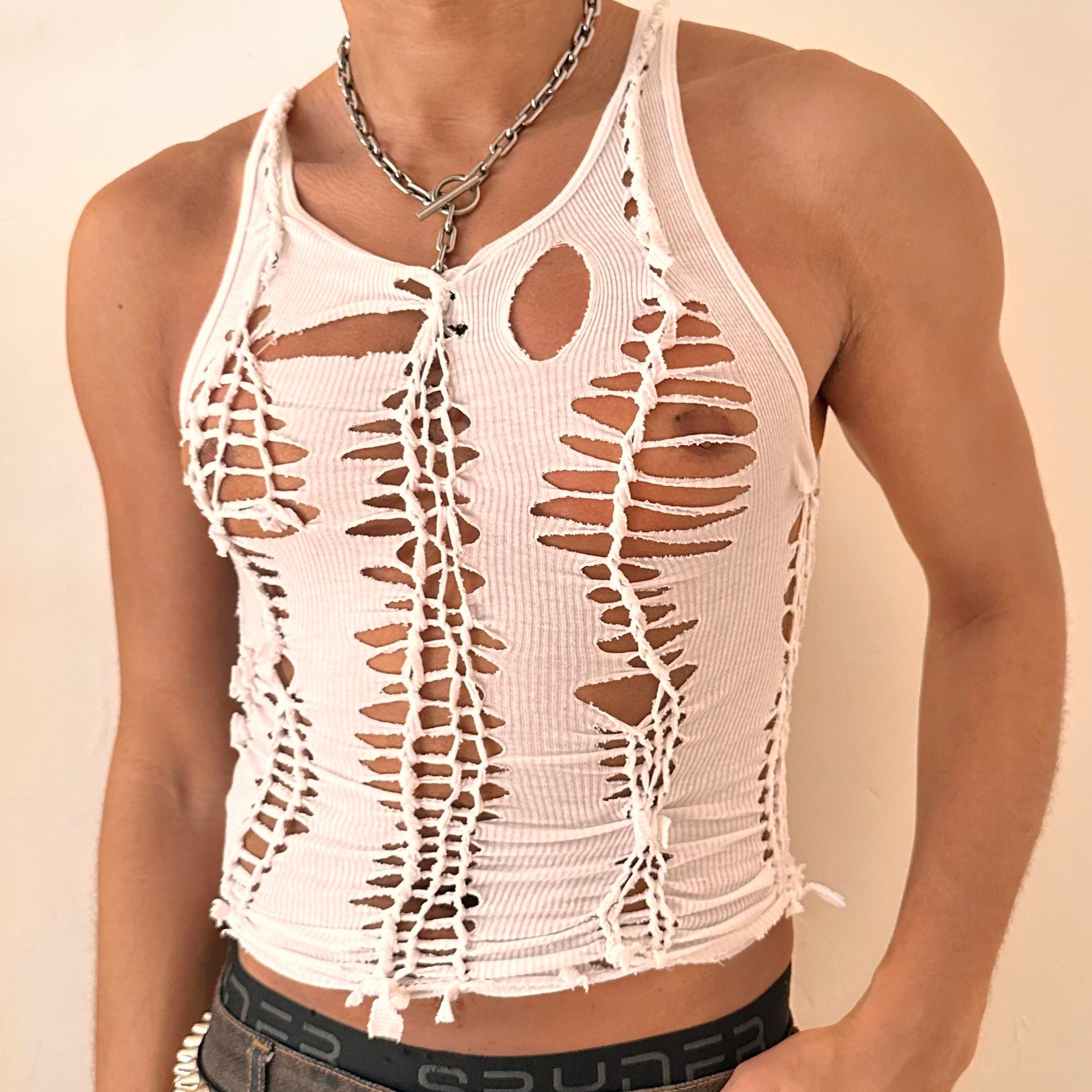 Close-up of ASTROBOI* 'Trinity' showing hand-braided twist construction and cut-out detailing on white cotton fabric.