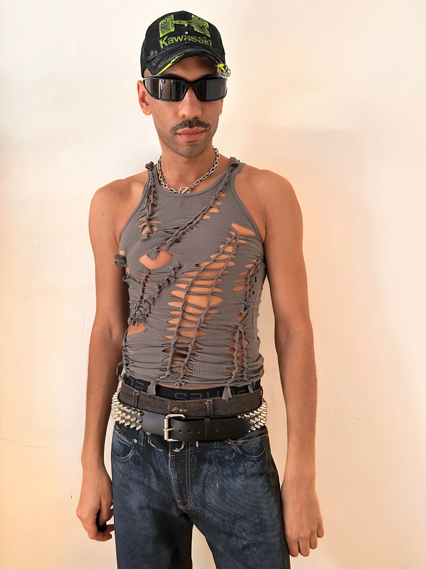 Styled image of ASTROBOI* 'Cypher' clay gray slim-fit tank top with hand-braided twist detailing and cut-outs contouring the torso, handmade at ASTROBOI* STUDIO in NYC.