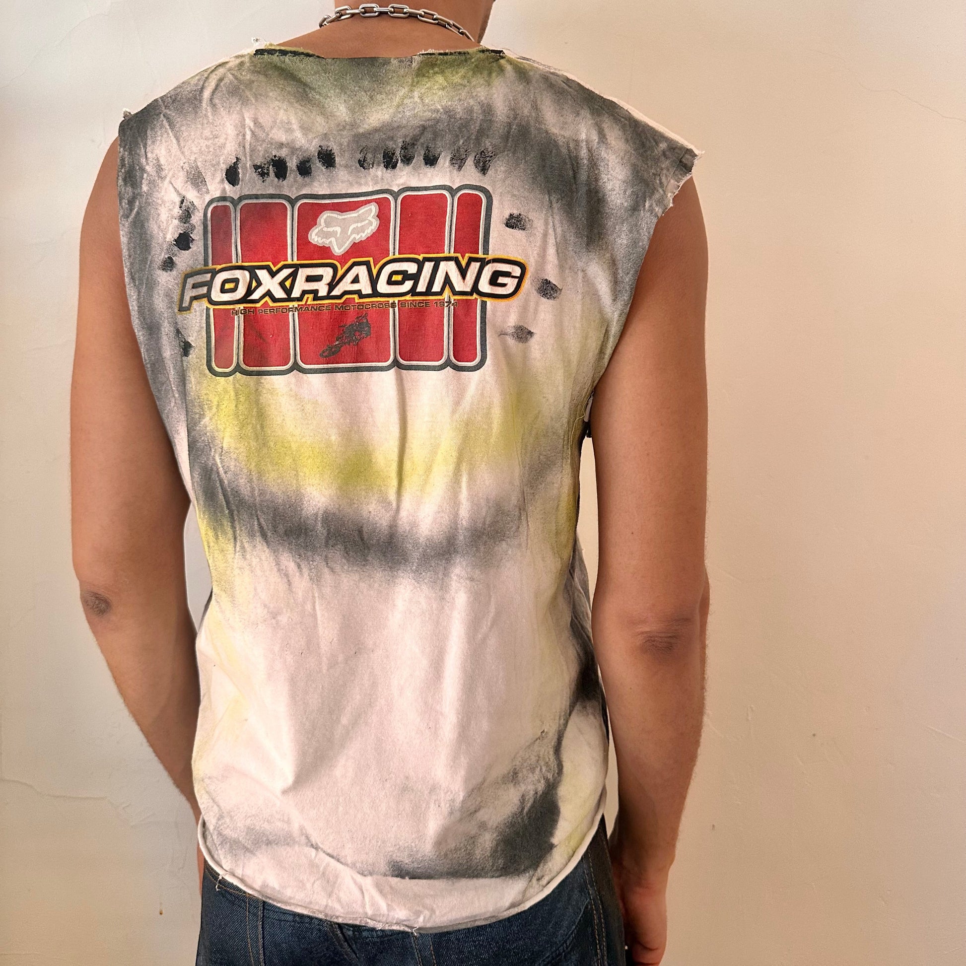 ASTROBOI* x Fox Racing white airbrushed motocross tank top, rear view showing black and acid yellow airbrush streak design, worn by male model.
