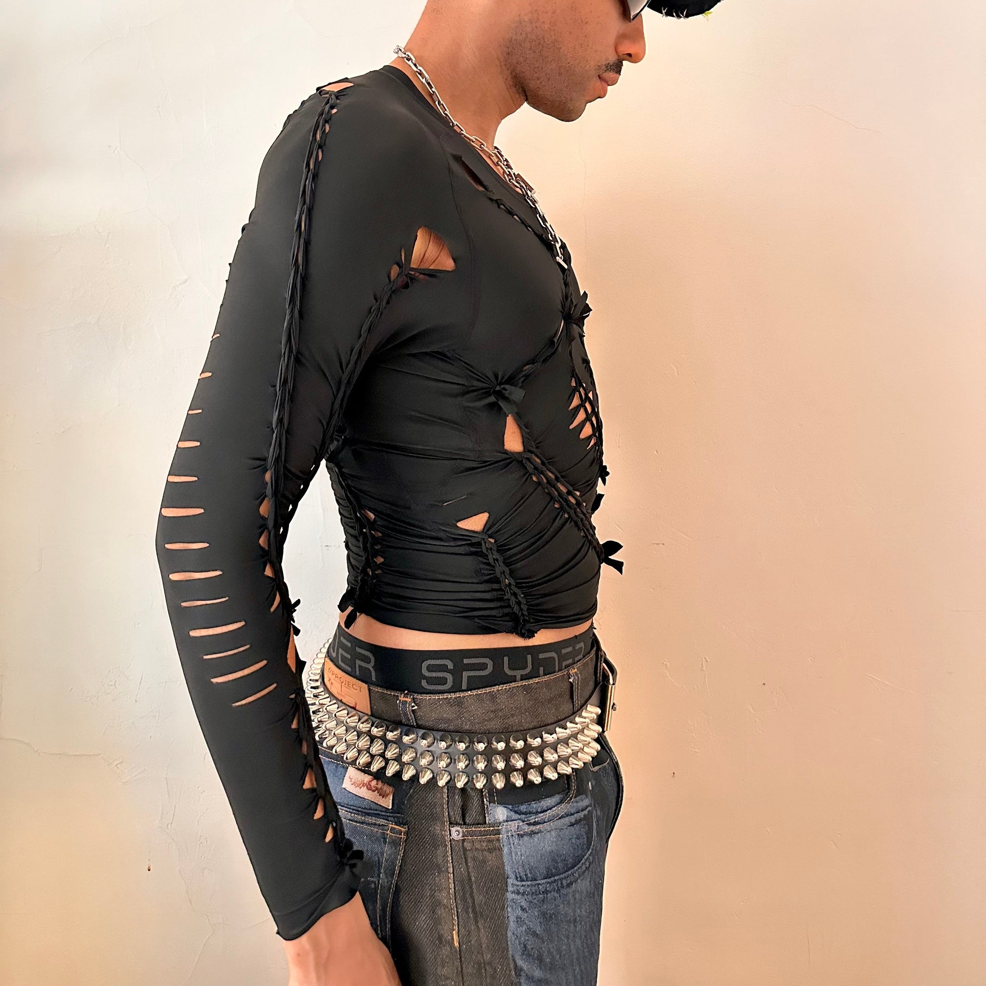 Right side detail of ASTROBOI* 'LEO' showing braided twist and slash construction on close-fitting black spandex base.