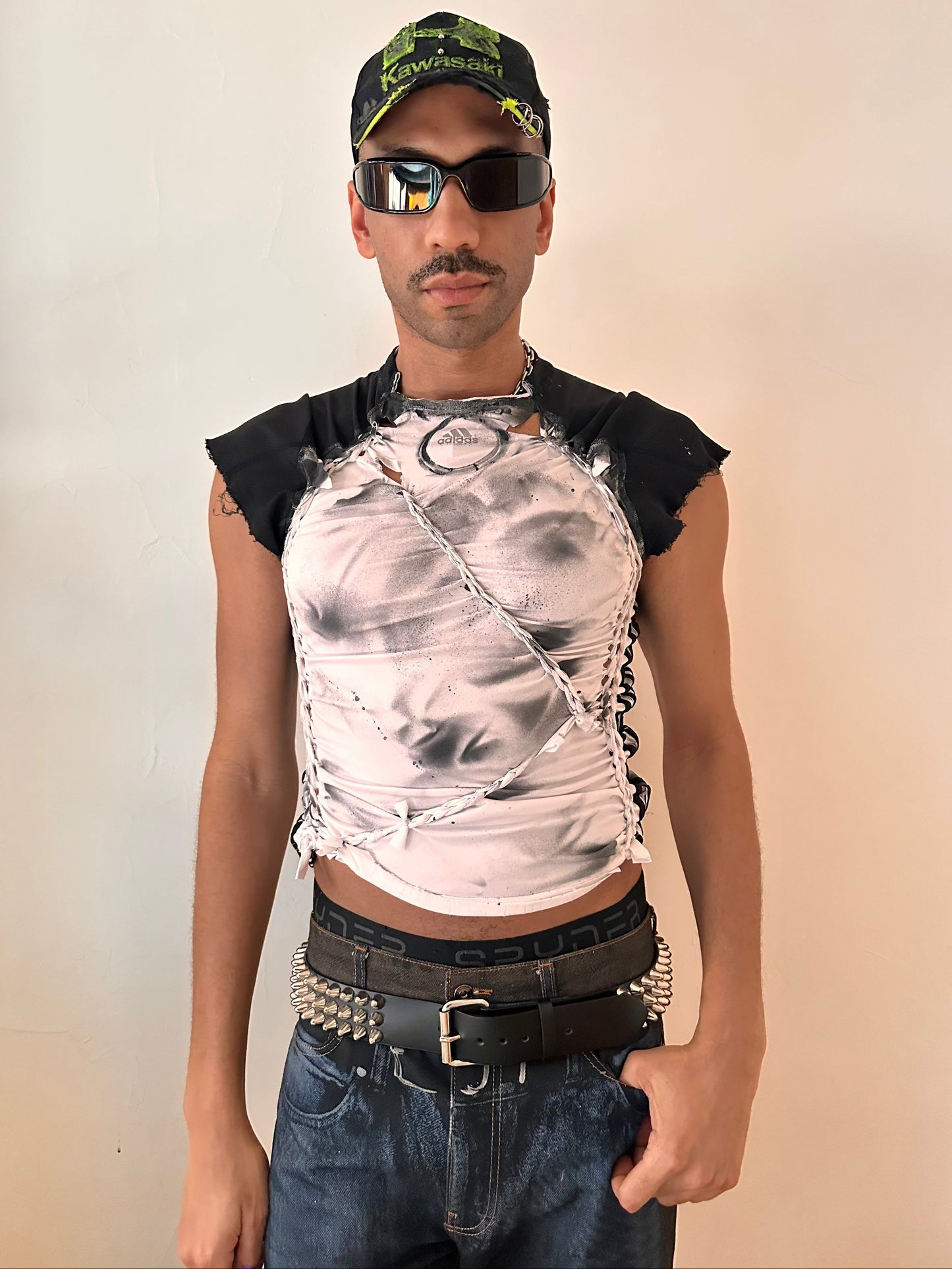 Styled image of ASTROBOI* x Adidas white compression T-shirt with black hand-painted details and braided twists. Custom streetwear piece made in NYC by ASTROBOI* STUDIO.