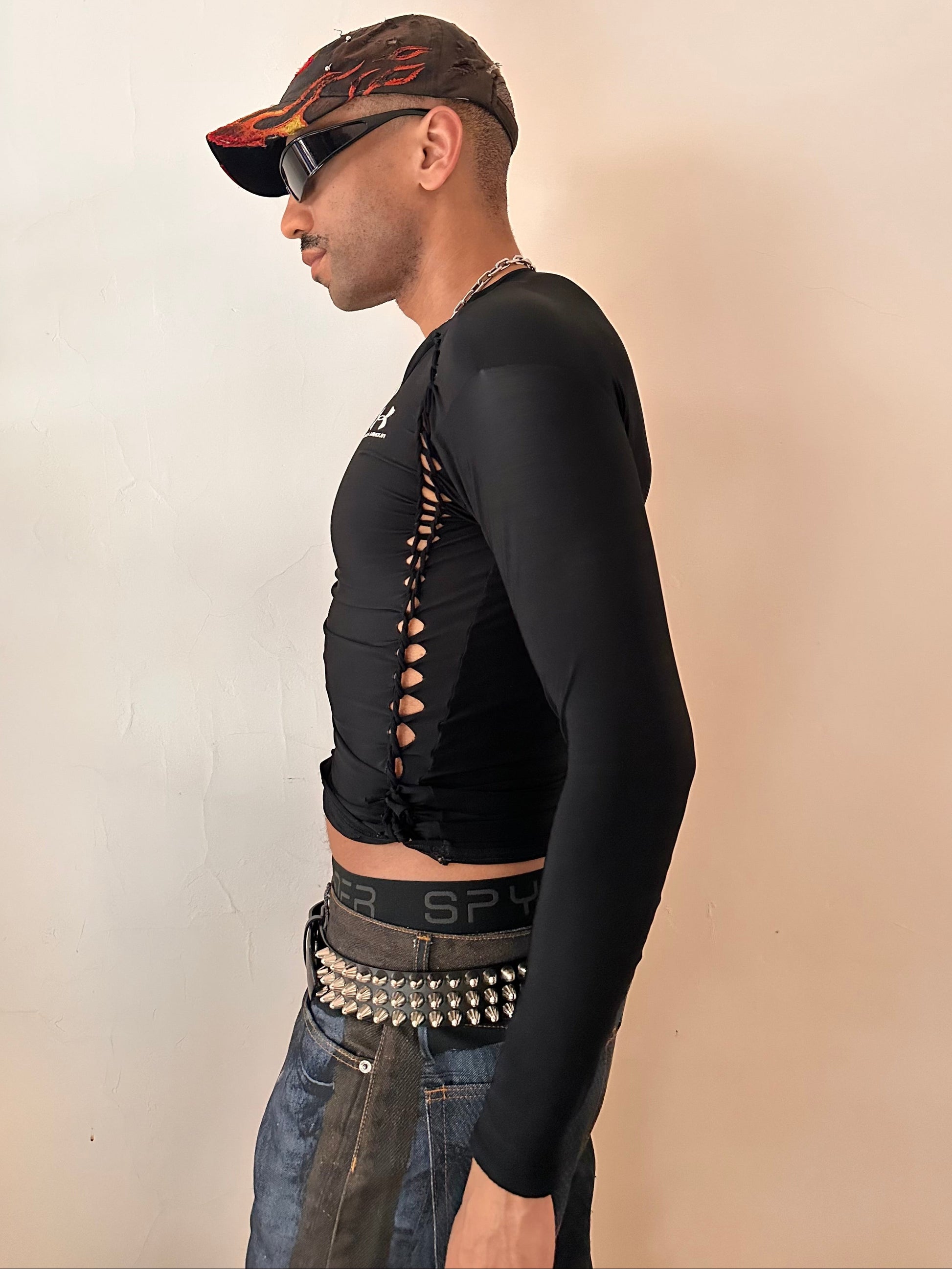 Left side of ASTROBOI* x Under Armour black braided compression top in large with slim stretch fit, twist detailing, and UA logos at chest and back.