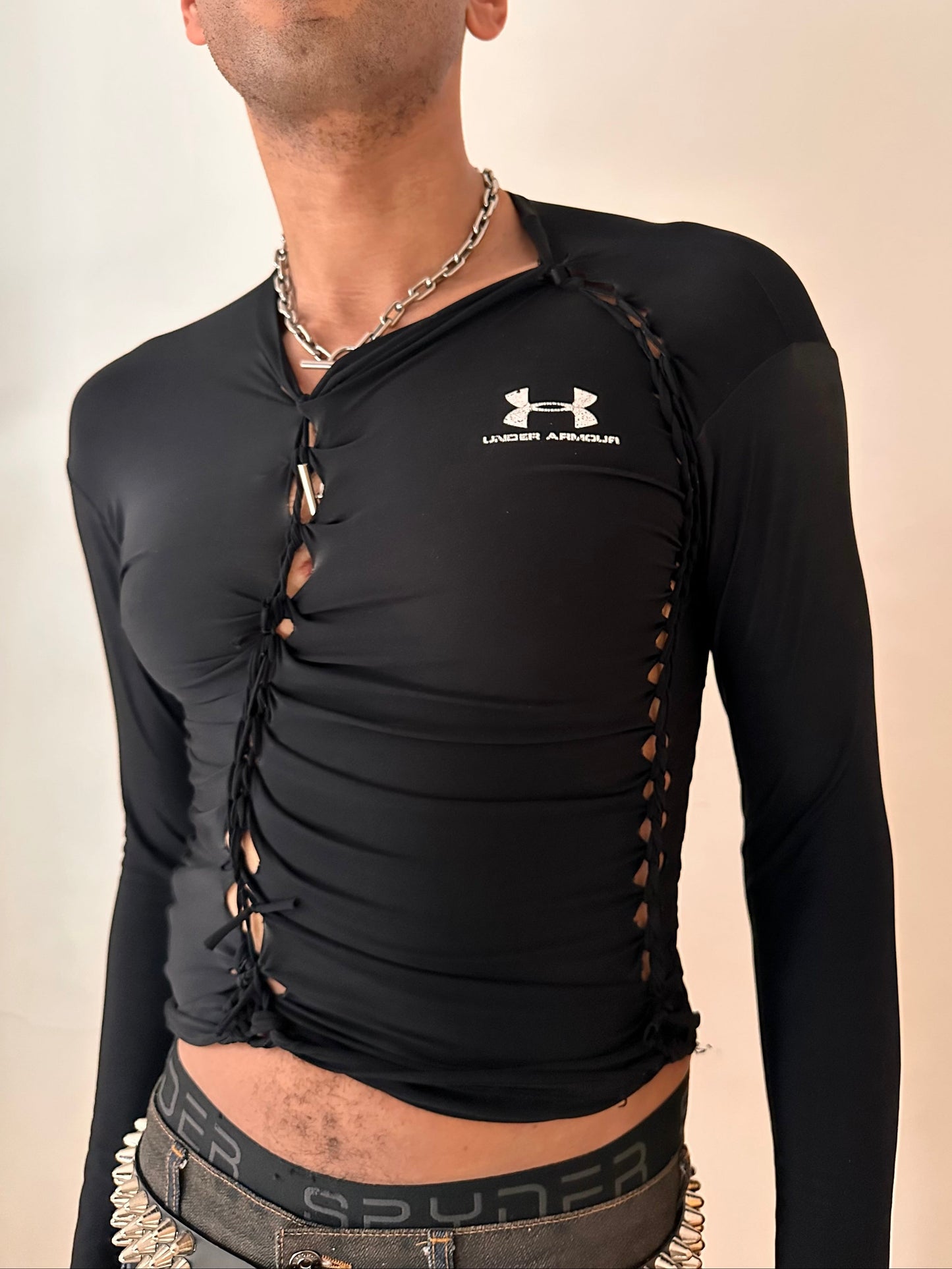 Front detail on ASTROBOI* x Under Armour black braided compression top in large with slim stretch fit, twist detailing, and UA logos at chest and back.