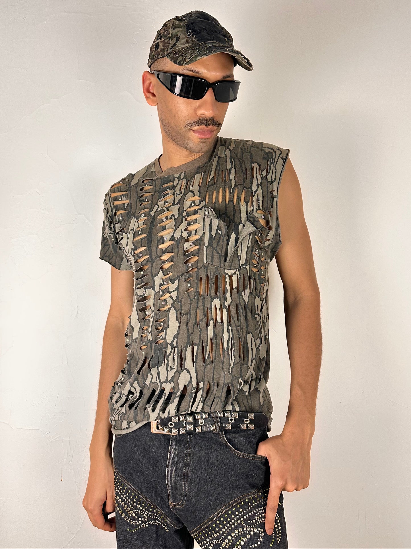 Male model wearing ASTROBOI* 'Maelstrom' Real Tree camo rhinestone tank top, styled full look, ASTROBOI* STUDIO Brooklyn NYC.
