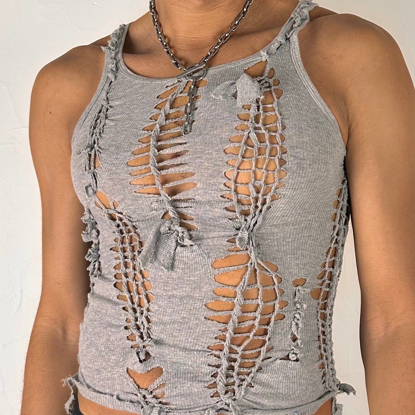 Close-up of ASTROBOI* 'Smoke' showing hand-braided construction, knot, and cut-out detailing on gray stretch cotton fabric.