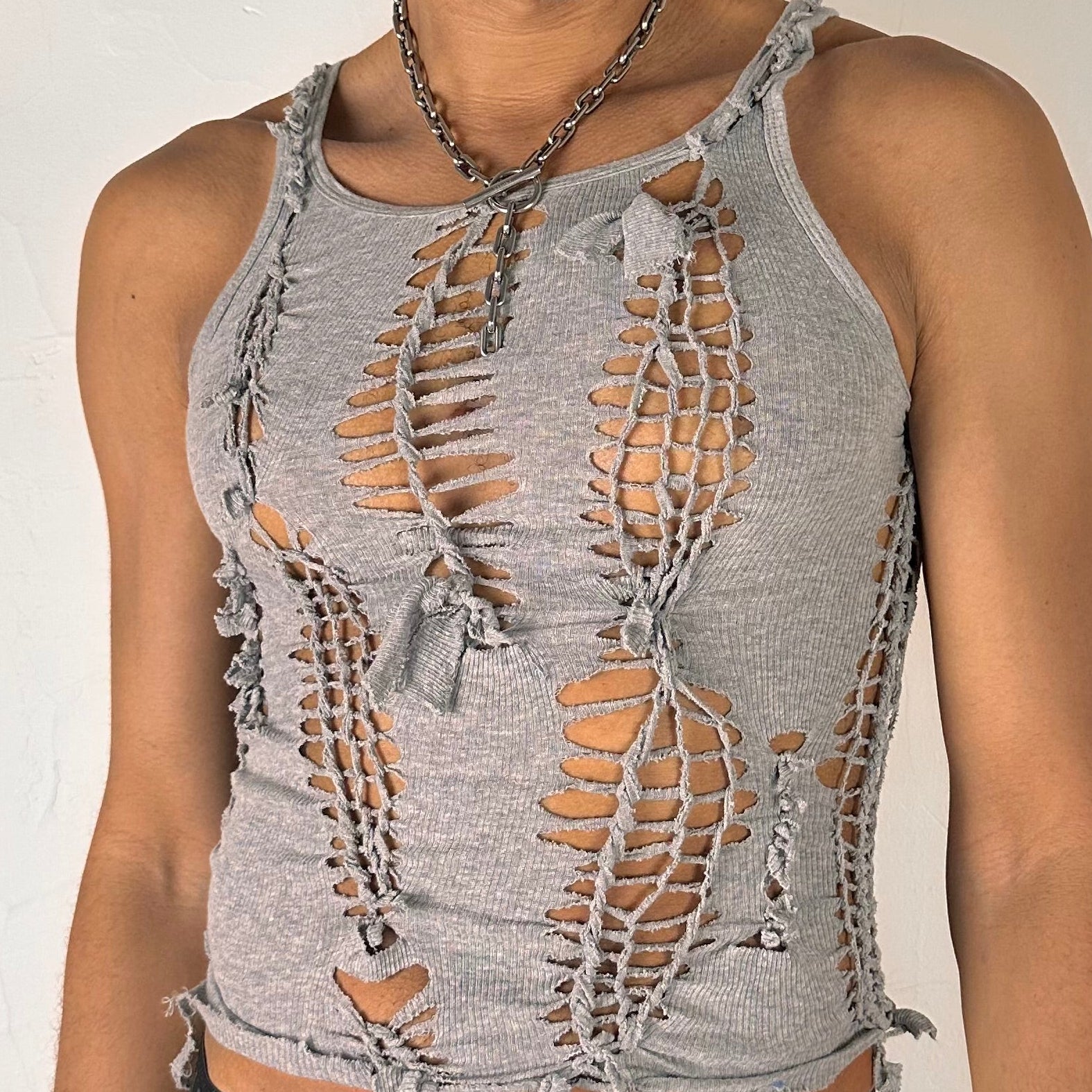 Close-up of ASTROBOI* 'Smoke' showing hand-braided construction, knot, and cut-out detailing on gray stretch cotton fabric.