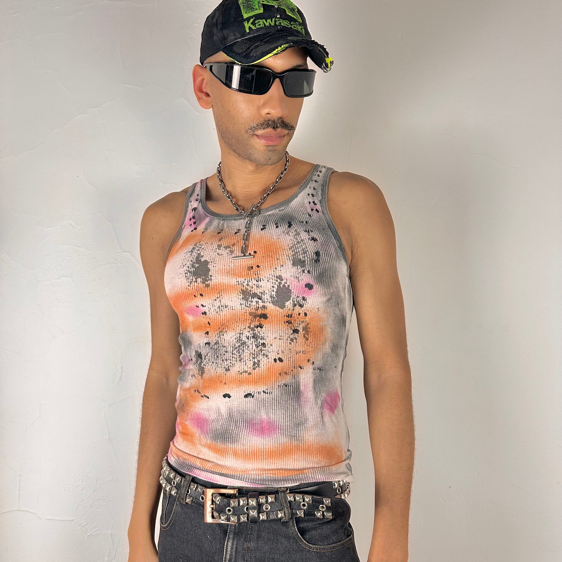 Styled image of ASTROBOI* x Hanes 'Mars' white ribbed cotton tank top with hand-painted pink, orange, and black abstract graphic, deconstructed cut-outs along chest and sides, customized at ASTROBOI* STUDIO in NYC.