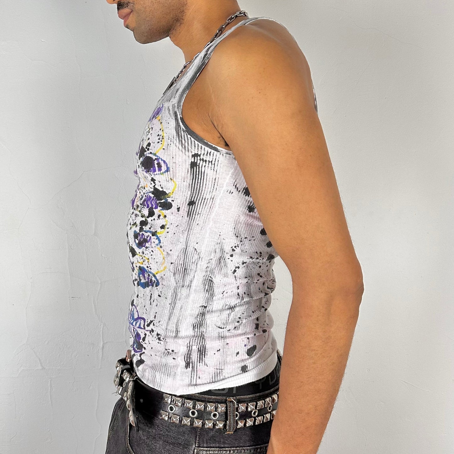 Left side detail of ASTROBOI* x Hanes 'Skies' showing abstract graffiti scribble and multicolored spot detailing on slim-fit white ribbed fabric.