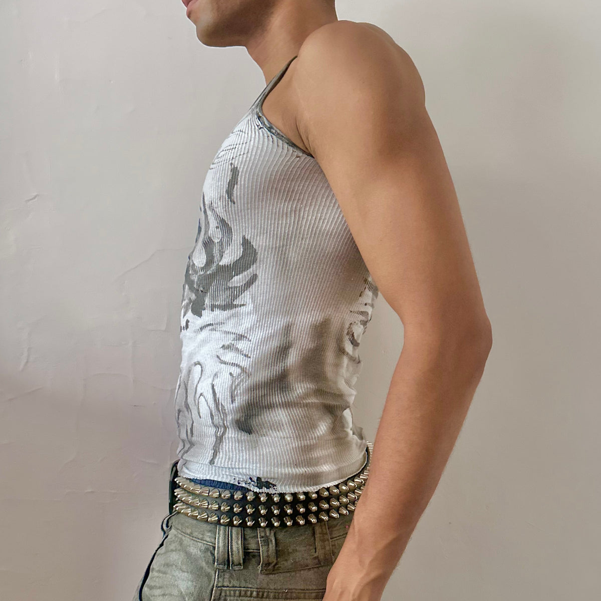 Left side detail of ASTROBOI* x Hanes 'Flame Thrower' showing hand drawn flame design, faded stain detail, and raw hemline on white tank.