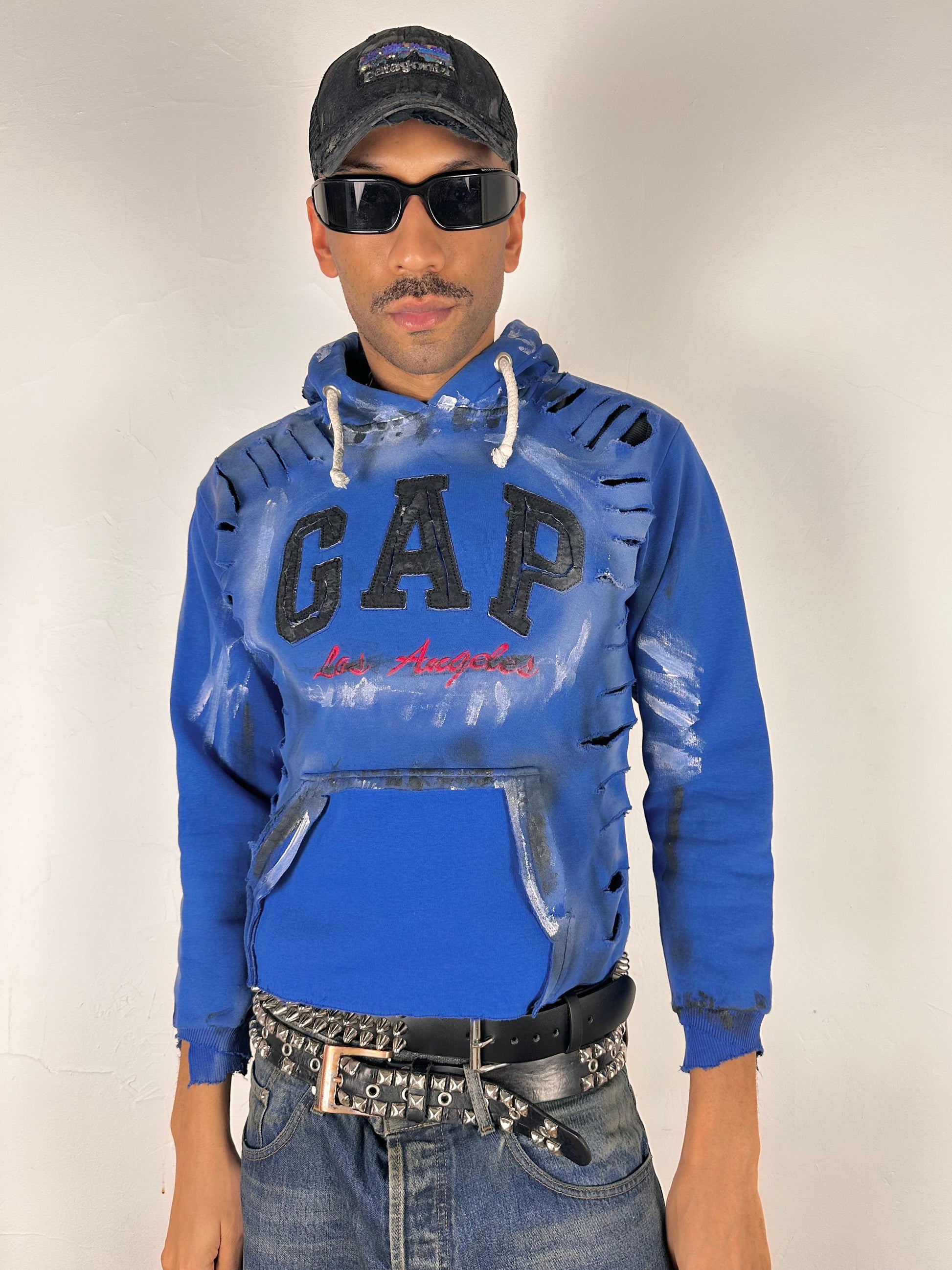 Styled image of ASTROBOI* x Gap blue distressed hoodie with airbrushed logo, ripped detailing, raw hem and rope drawcords, size Large loose fit.