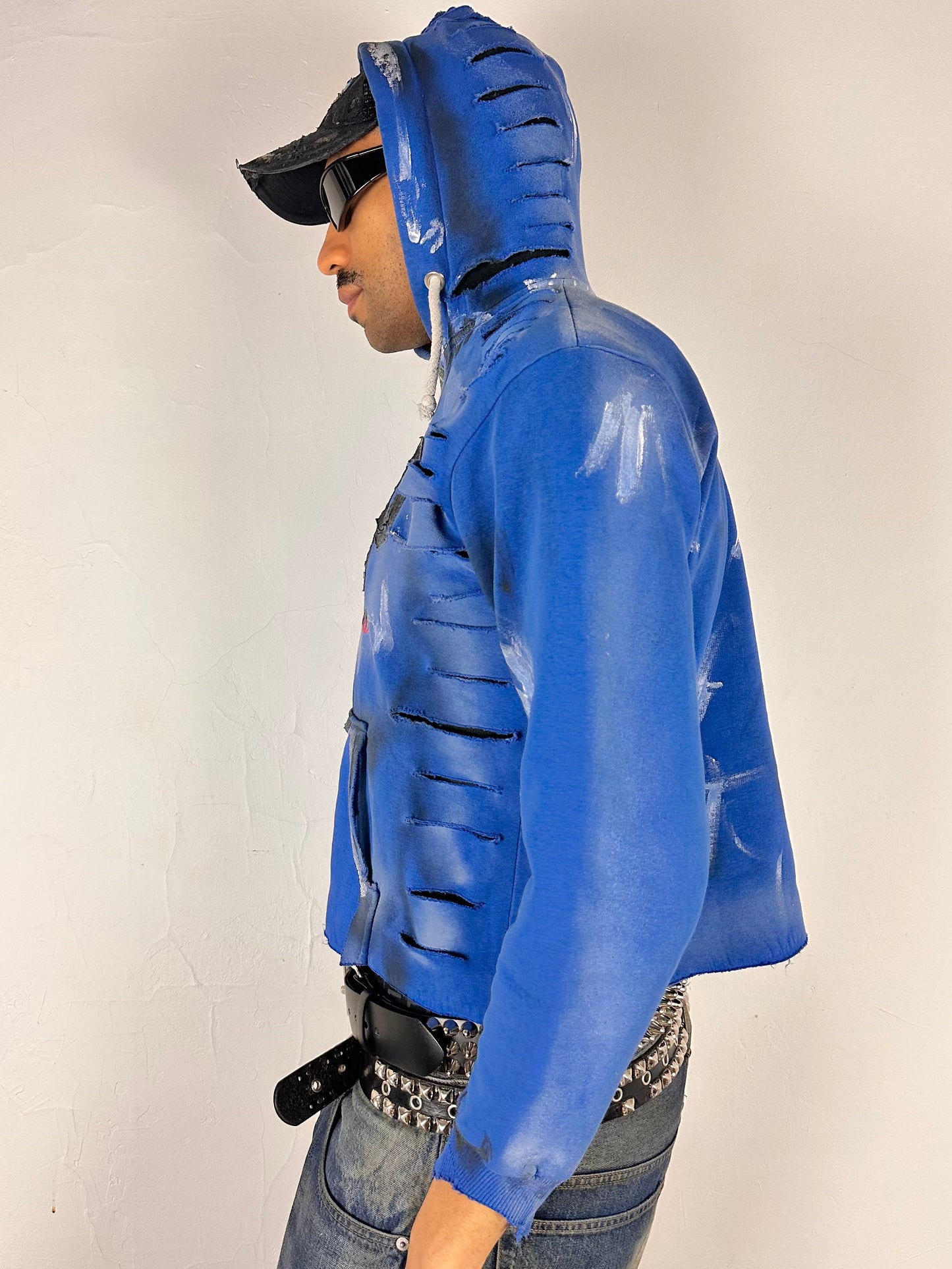 Left side of ASTROBOI* x Gap blue distressed hoodie with airbrushed logo, ripped detailing, raw hem and rope drawcords, size Large loose fit.