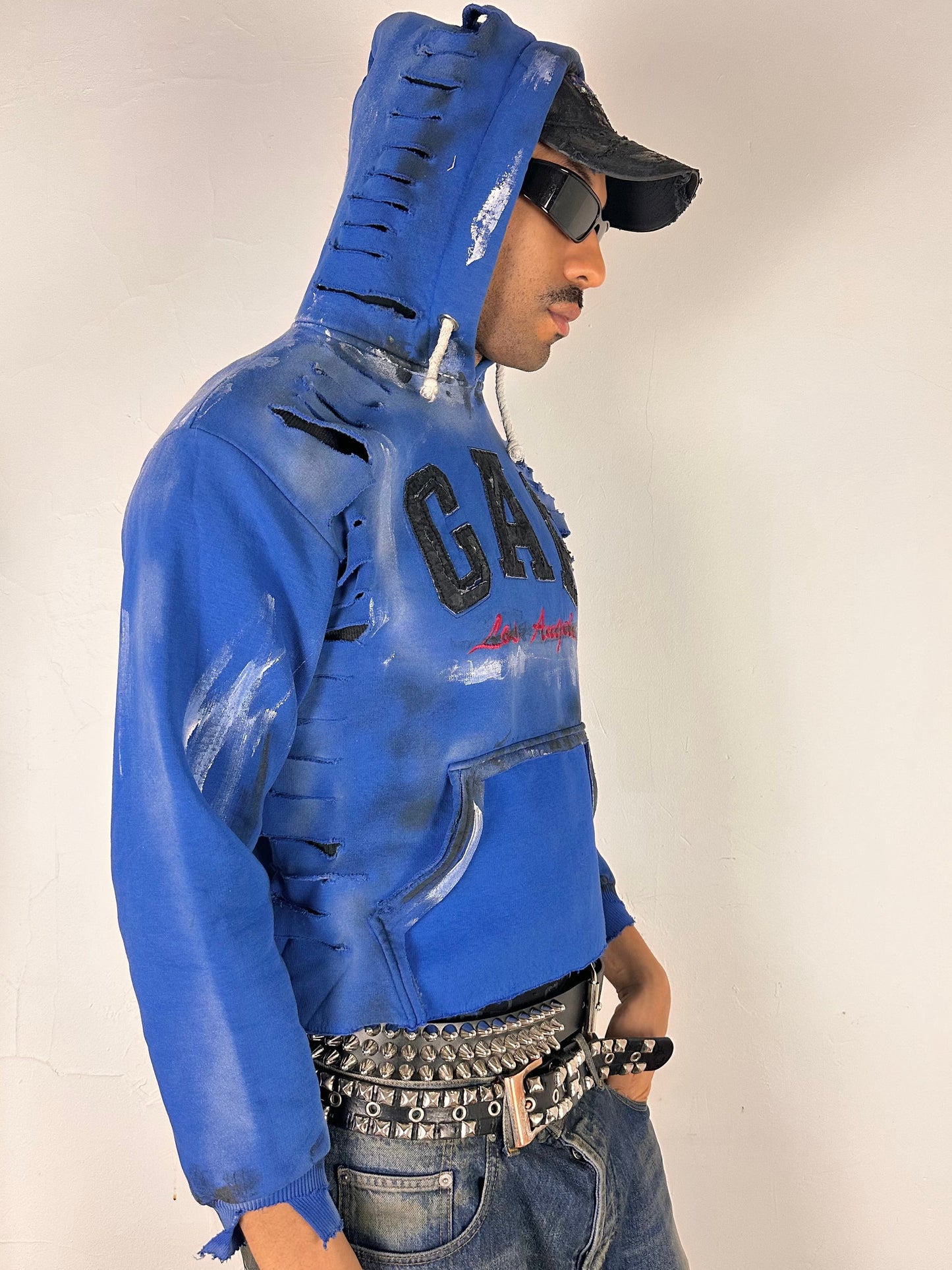 Right side of ASTROBOI* x Gap blue distressed hoodie with airbrushed logo, ripped detailing, raw hem and rope drawcords, size Large loose fit.