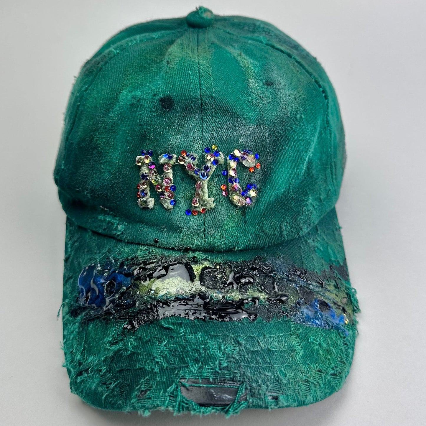 Overview of ASTROBOI* Smith NYC green distressed hat with clear rhinestone logo, custom paint treatment and blue black resin textured visor.
