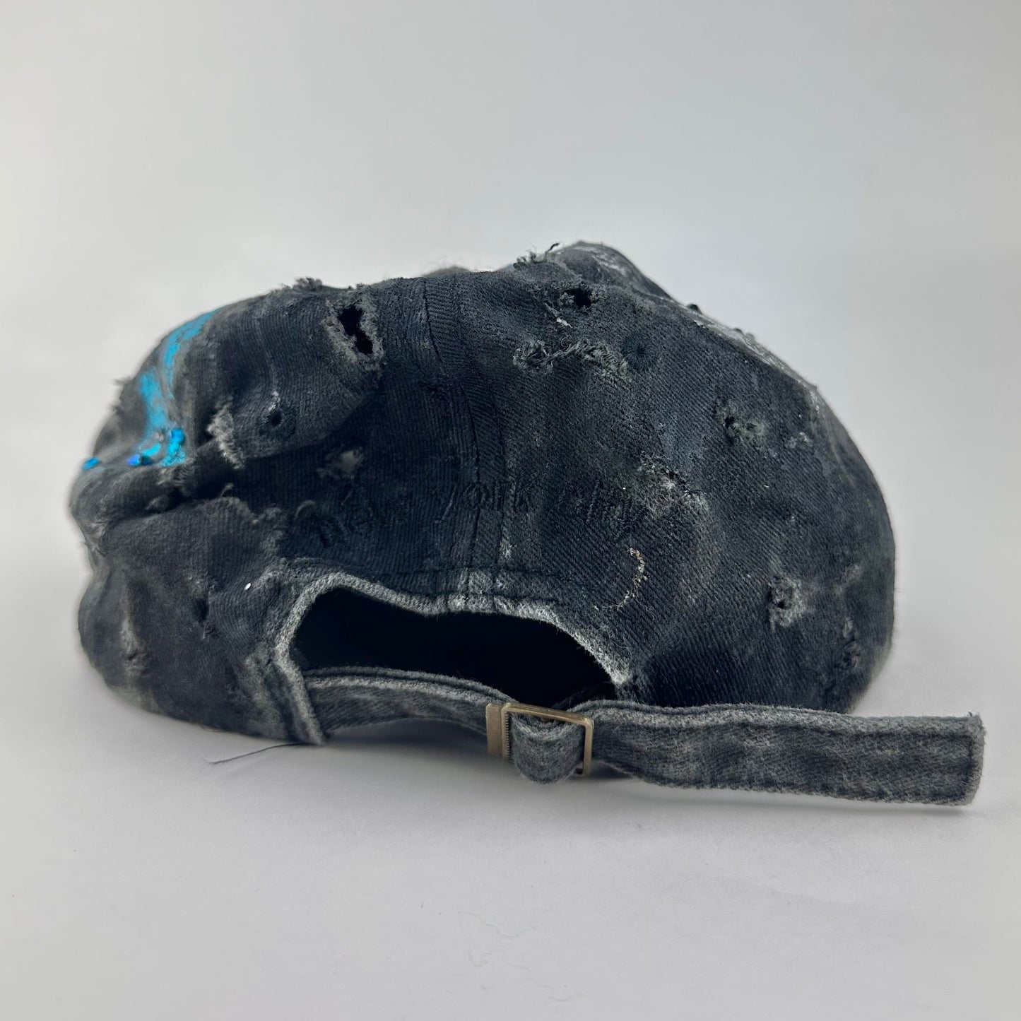 Back of ASTROBOI* Plavala black iridescent hat with rhinestone NYC logos, metallic paint and black clear resin creating a hazy milky way effect.