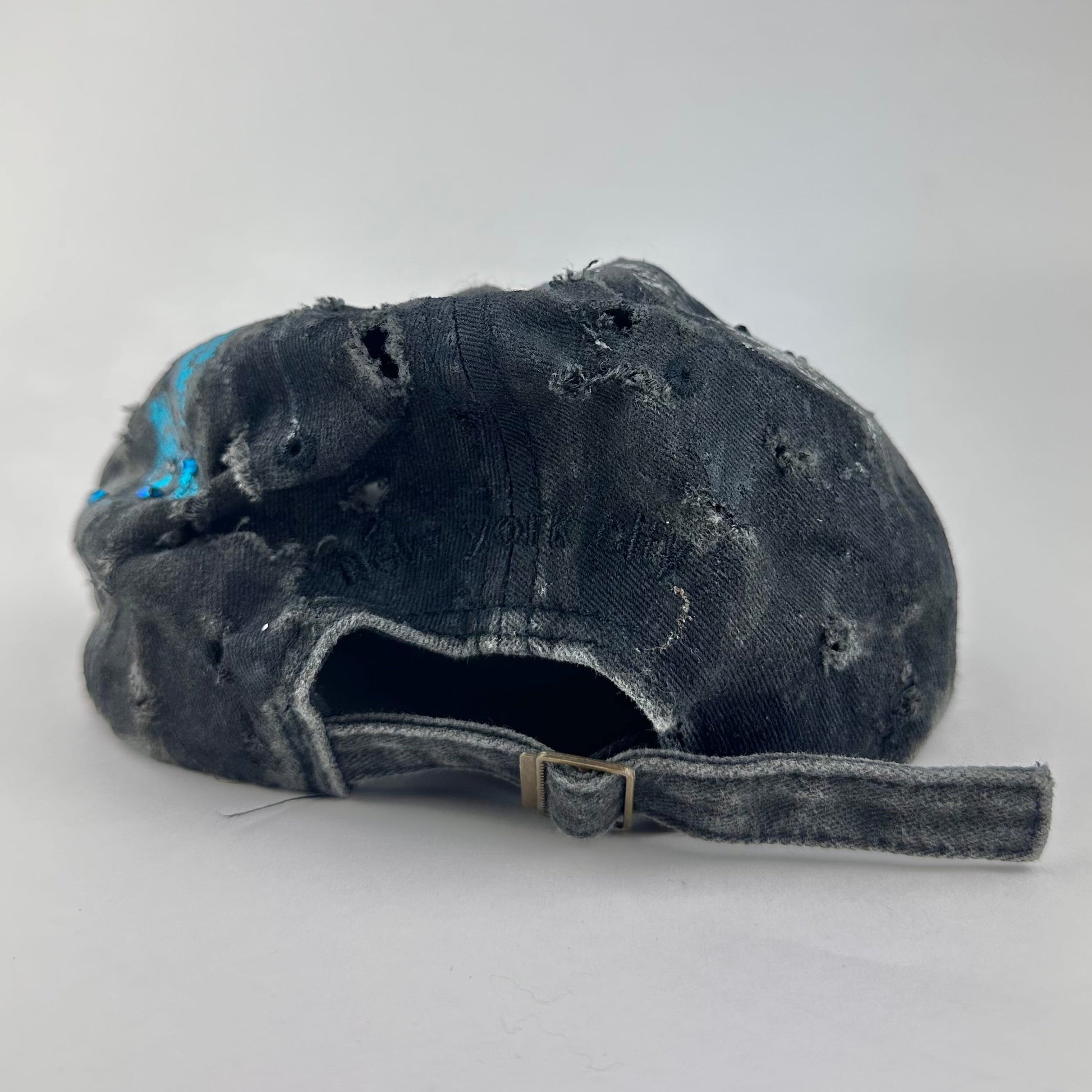 Back of ASTROBOI* Plavala black iridescent hat with rhinestone NYC logos, metallic paint and black clear resin creating a hazy milky way effect.