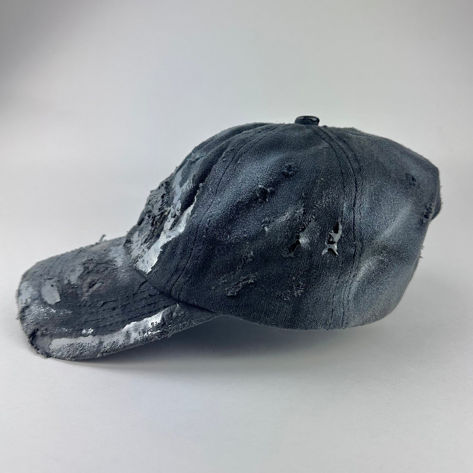 Left side of ASTROBOI* Brooklyn distressed black baseball hat with 3D black resin slime over embroidery and adjustable back strap, handmade in NYC.