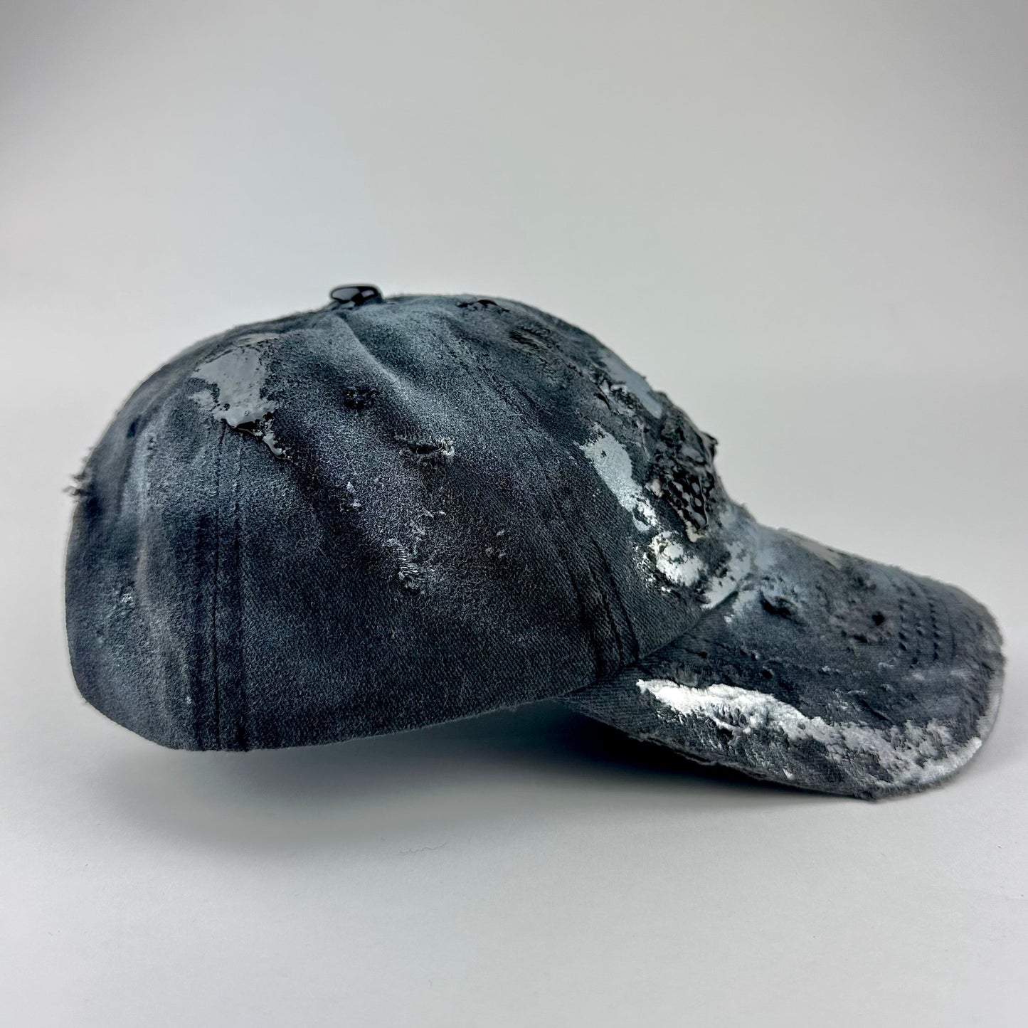 Right side of ASTROBOI* Brooklyn distressed black baseball hat with 3D black resin slime over embroidery and adjustable back strap, handmade in NYC.