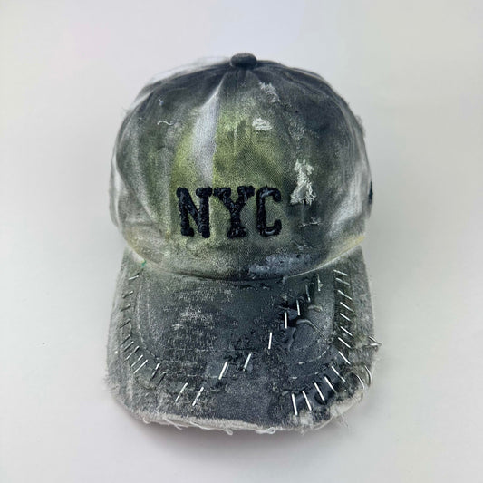 Front flat lay of ASTROBOI* white NYC dad hat with clear resin logo, black and green abstract paint details, adjustable strap back