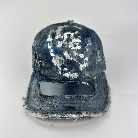 Front flay lay on Black acid-washed denim hat with silver paint accents, multicolored rhinestones, and a ripped visor seam, customized by ASTROBOI* STUDIO.