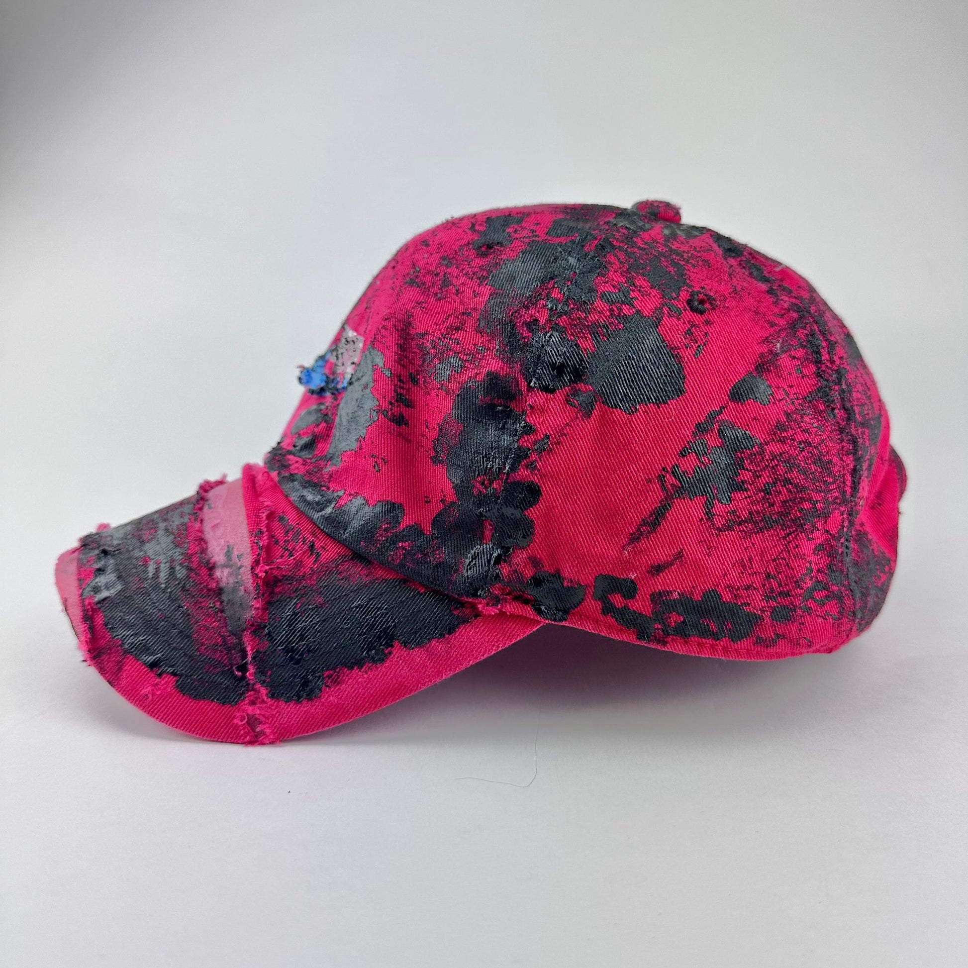 Left side detail of ASTROBOI* x Nike 'Comet' showing distressed texture and black paint detailing on red hat.