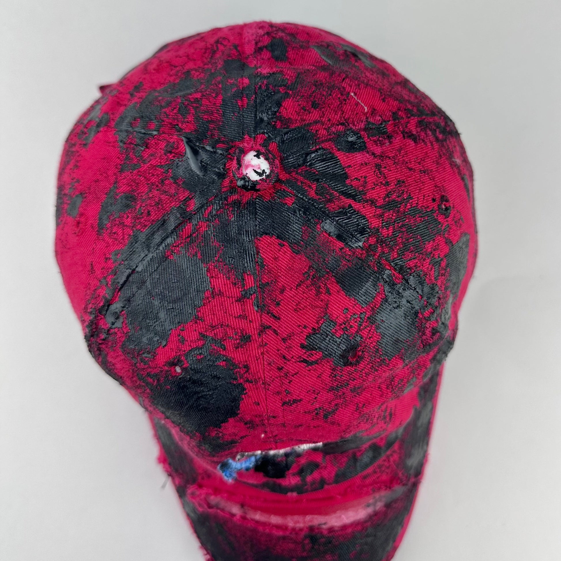 Top side detail of ASTROBOI* x Nike 'Comet' showing black painted pattern and distressed finish on red base.