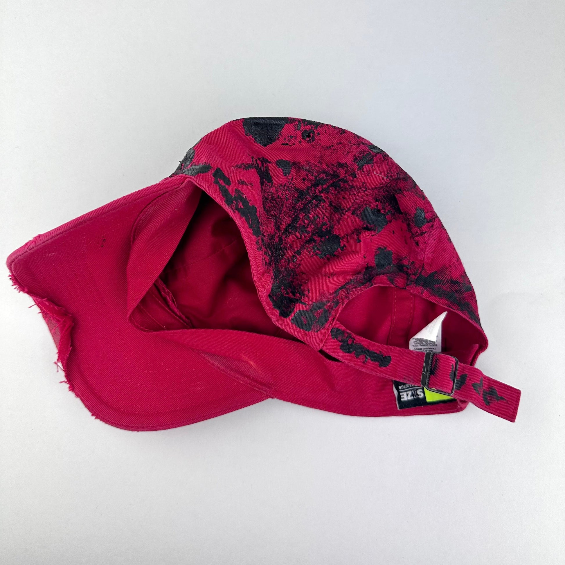 ASTROBOI* x Nike 'Comet' red and black painted distressed hat, rear view showing adjustable back and distressed finish.
