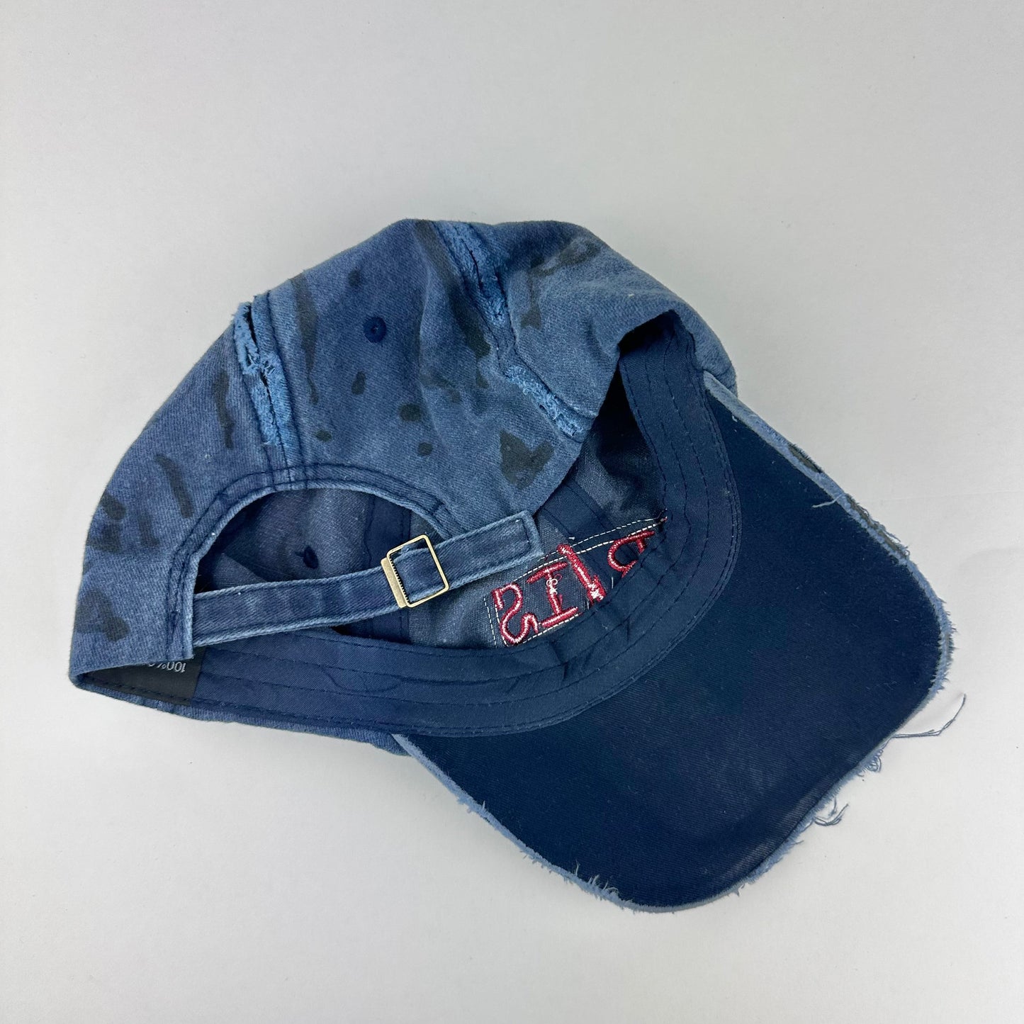 Back of ASTROBOI* Lights of Paris blue baseball hat with Eiffel Tower embroidery, black graffiti print and red orange rhinestone crystals.